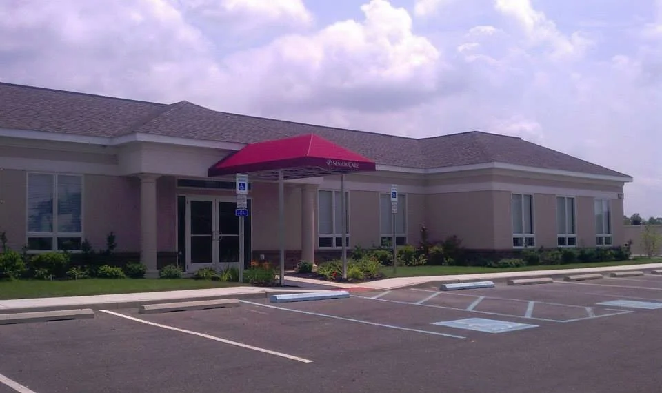 Single-story building with a parking lot, has an awning over the entrance, and is labeled 'Senior Care'.