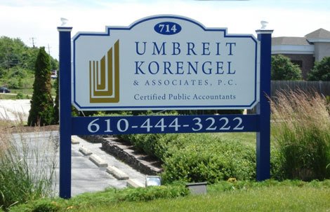 Sign for Umbreit Korengel & Associates, P.C., certified public accountants, with a phone number 610-444-3222, located in a landscaped area.