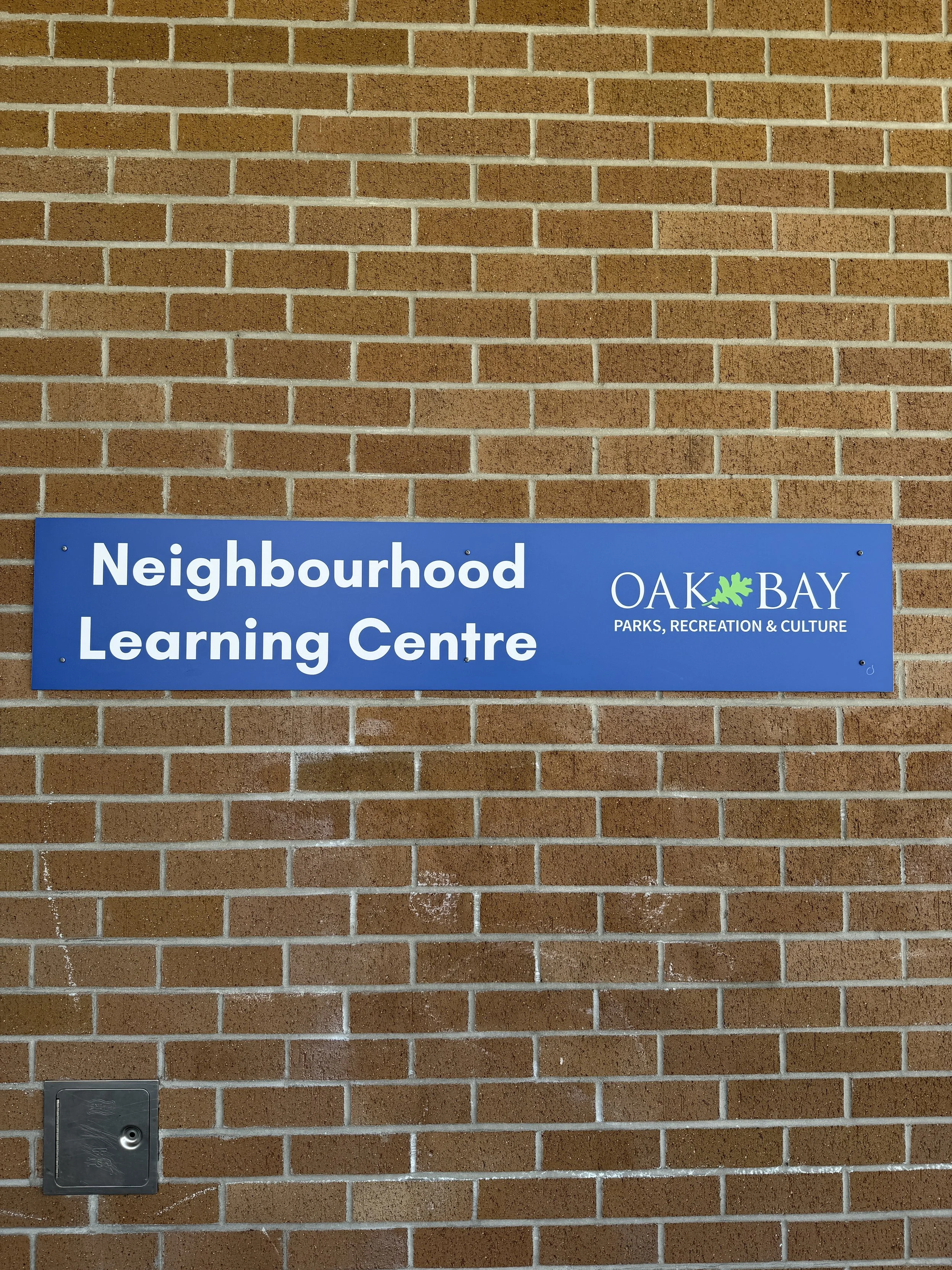 a brick wall with "neighbourhood learning centre" sign