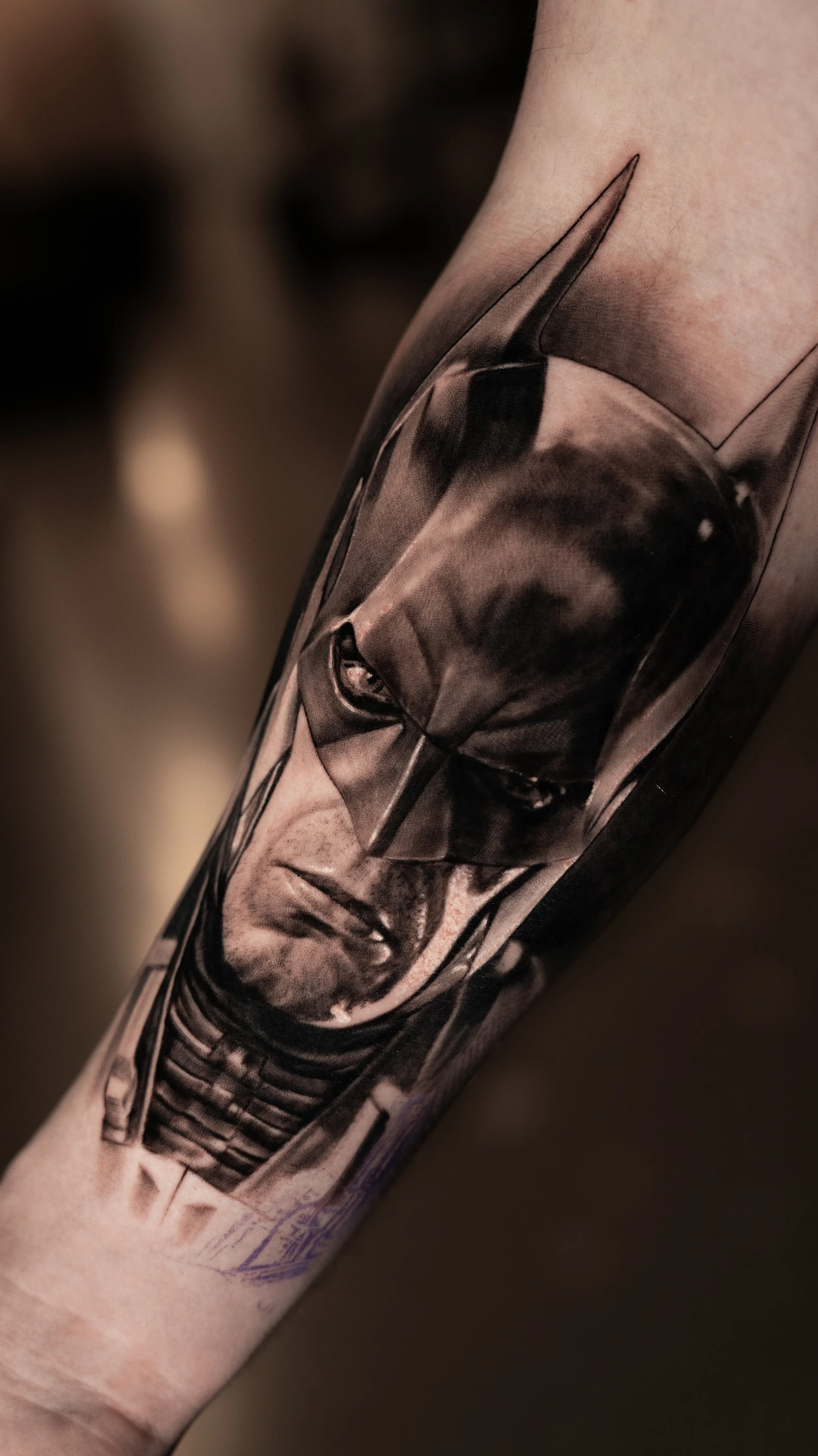 Black and gray realistic portrait tattoo of Darth Vader from Star Wars on person's arm.