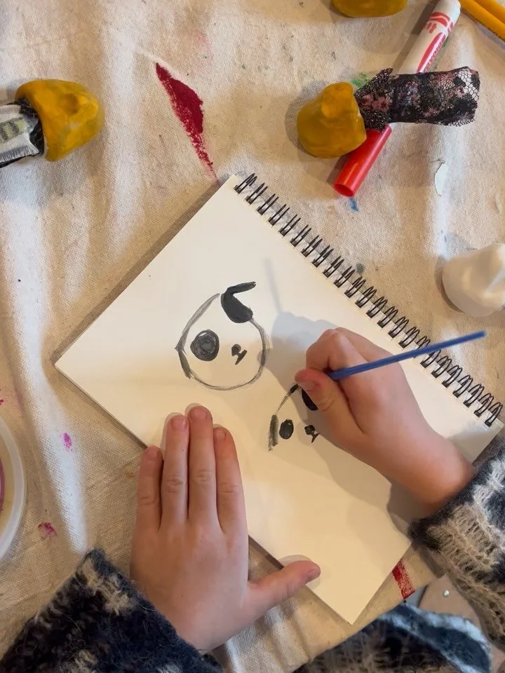 Making finger puppets. Practicing painting in sketchbooks before paint goes on on puppet.