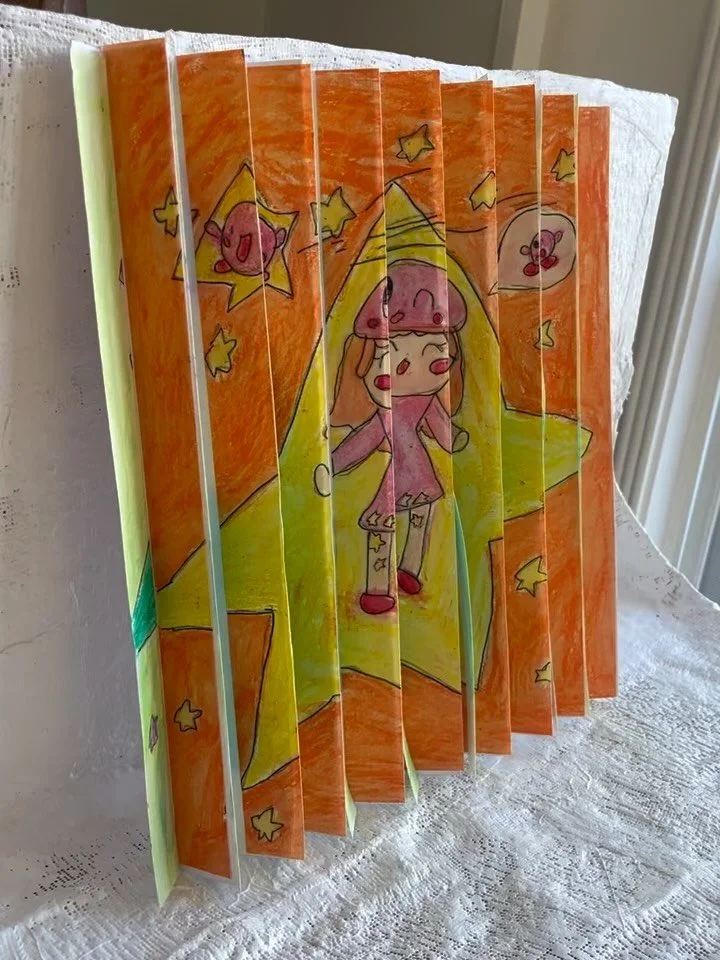 3D fanned drawings. The picture changes as you walk around. In our version, we used transfer paper to make 2 copies of the same drawing, but colored one with warm colors and the other with cool. Pretty groovy!