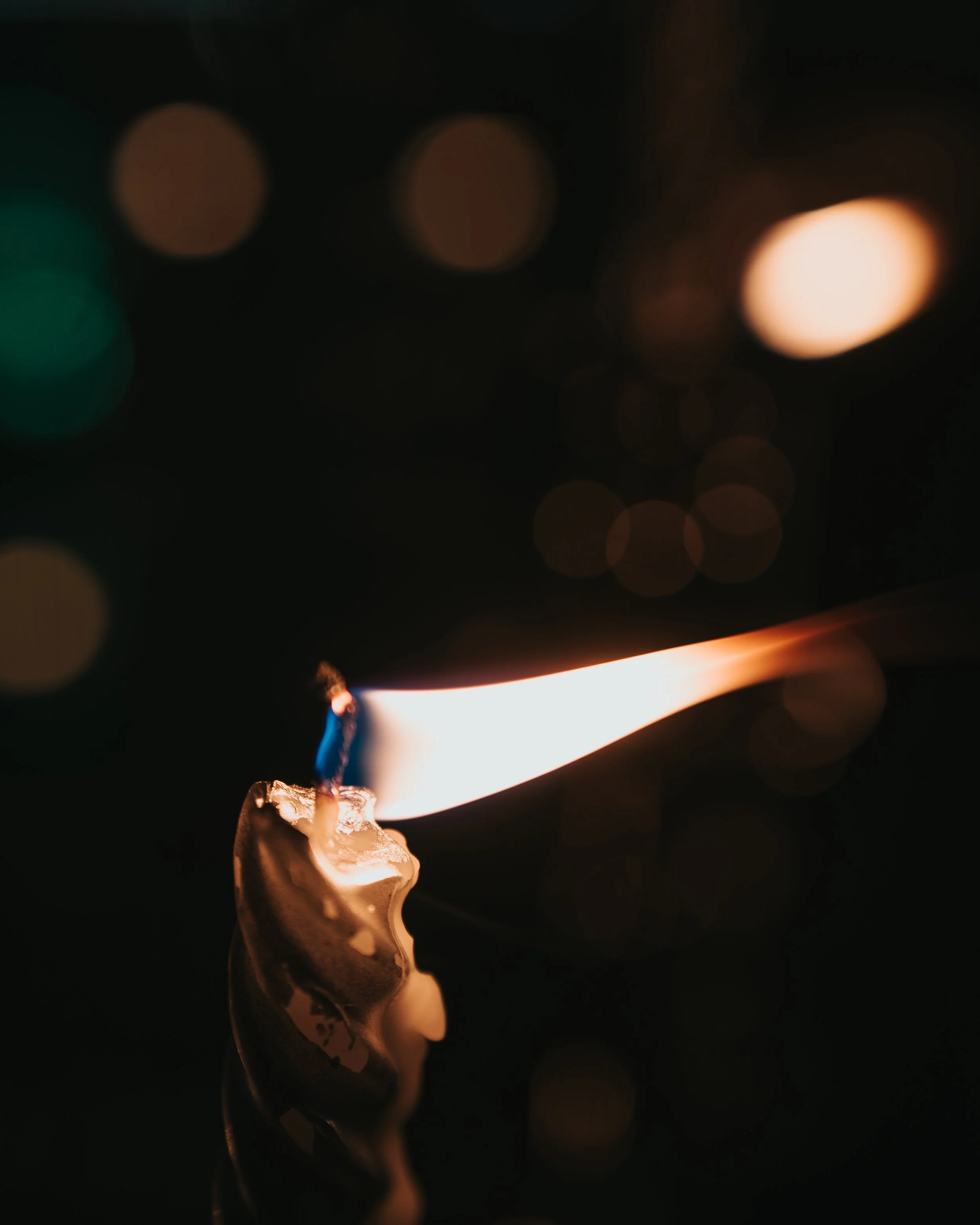 A burning matchstick with a bright flame against a dark background.