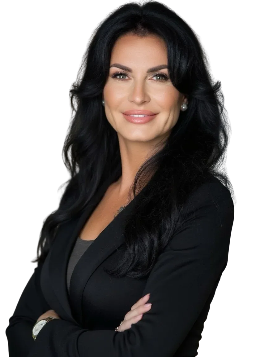 A woman with long black hair wearing a black blazer and pearl earrings, smiling confidently.