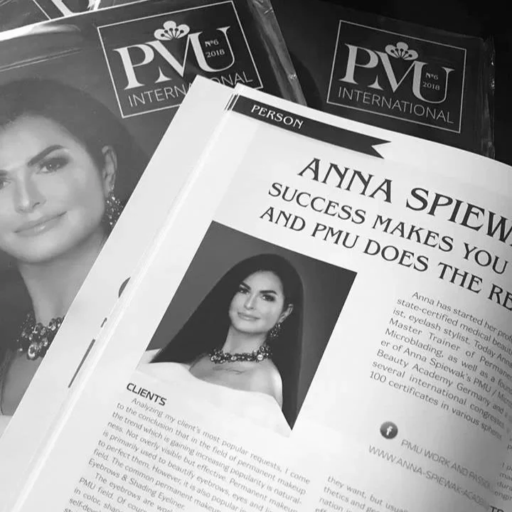 Close-up of printed makeup artist profile featuring Anna Spiewak, with two PMU international brochures in the background.