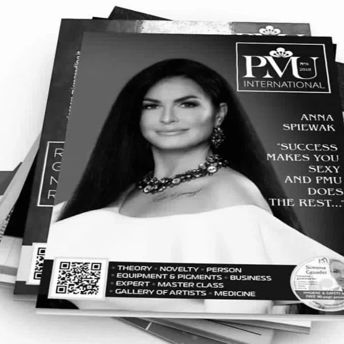 Black and white magazine cover featuring a woman with long dark hair, wearing jewelry and a white off-the-shoulder top, with a quote about success. The magazine is titled 'PMU International' and includes a QR code and additional text about various topics.