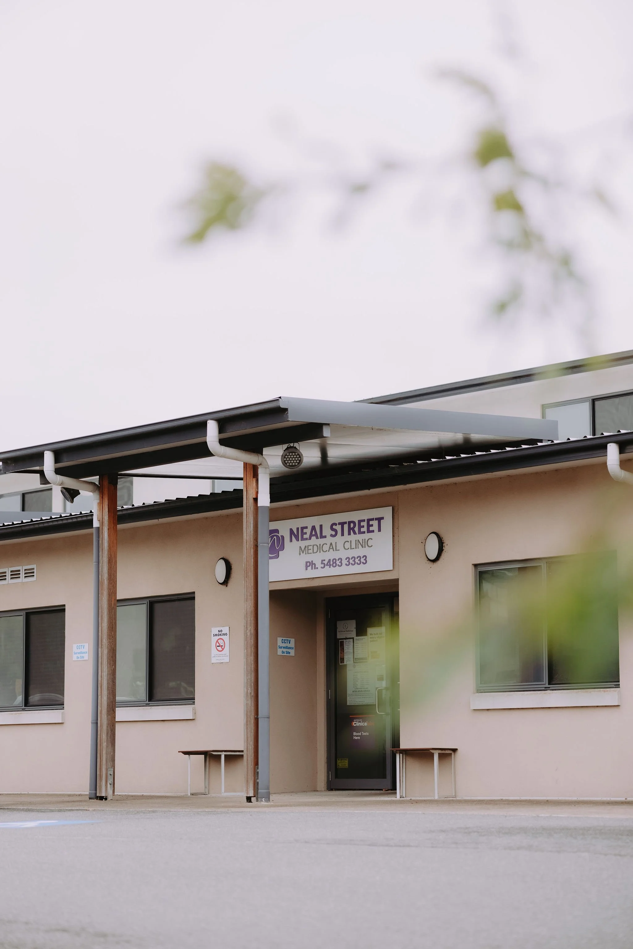 Exterior of Neal Street Medical Clinic building with signs, windows, and a door.