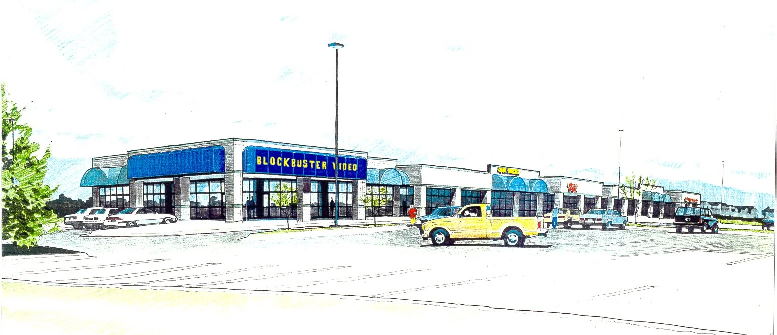 A shopping plaza parking lot with a Blockbuster Video store, several parked cars, and a pickup truck driving through.