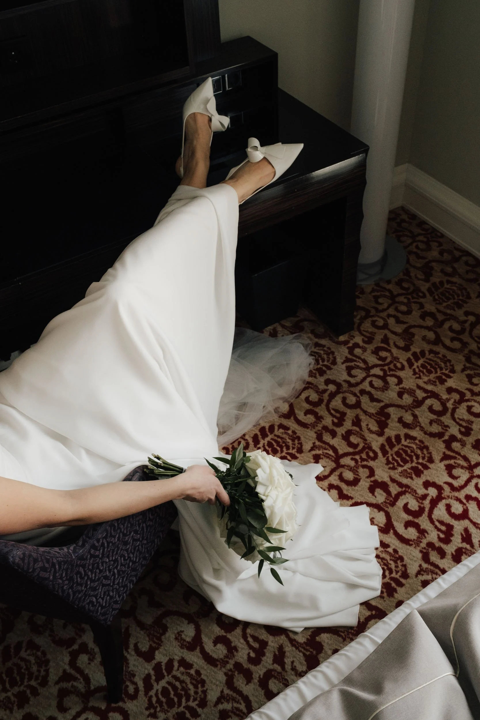 Editorial Hochzeitsfotografie Hamburg: Braut-Details beim Getting Ready im Hotel Atlantic. Weißer Rosenstrauß und elegante Brautschuhe, fotografiert von Valeska Weddings im dokumentarischen Stil.