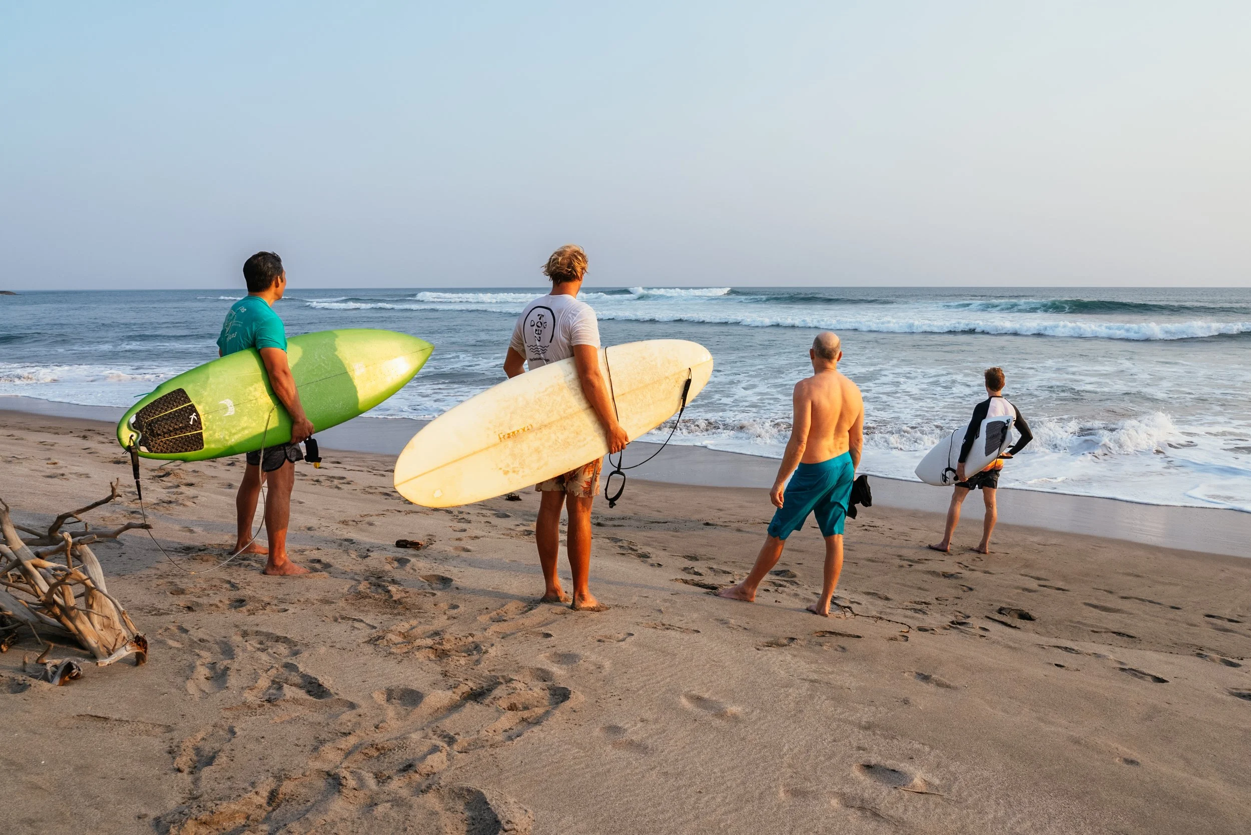 four surfers standing on a beach, lifestyle photo from lifestyle director Roo Smith