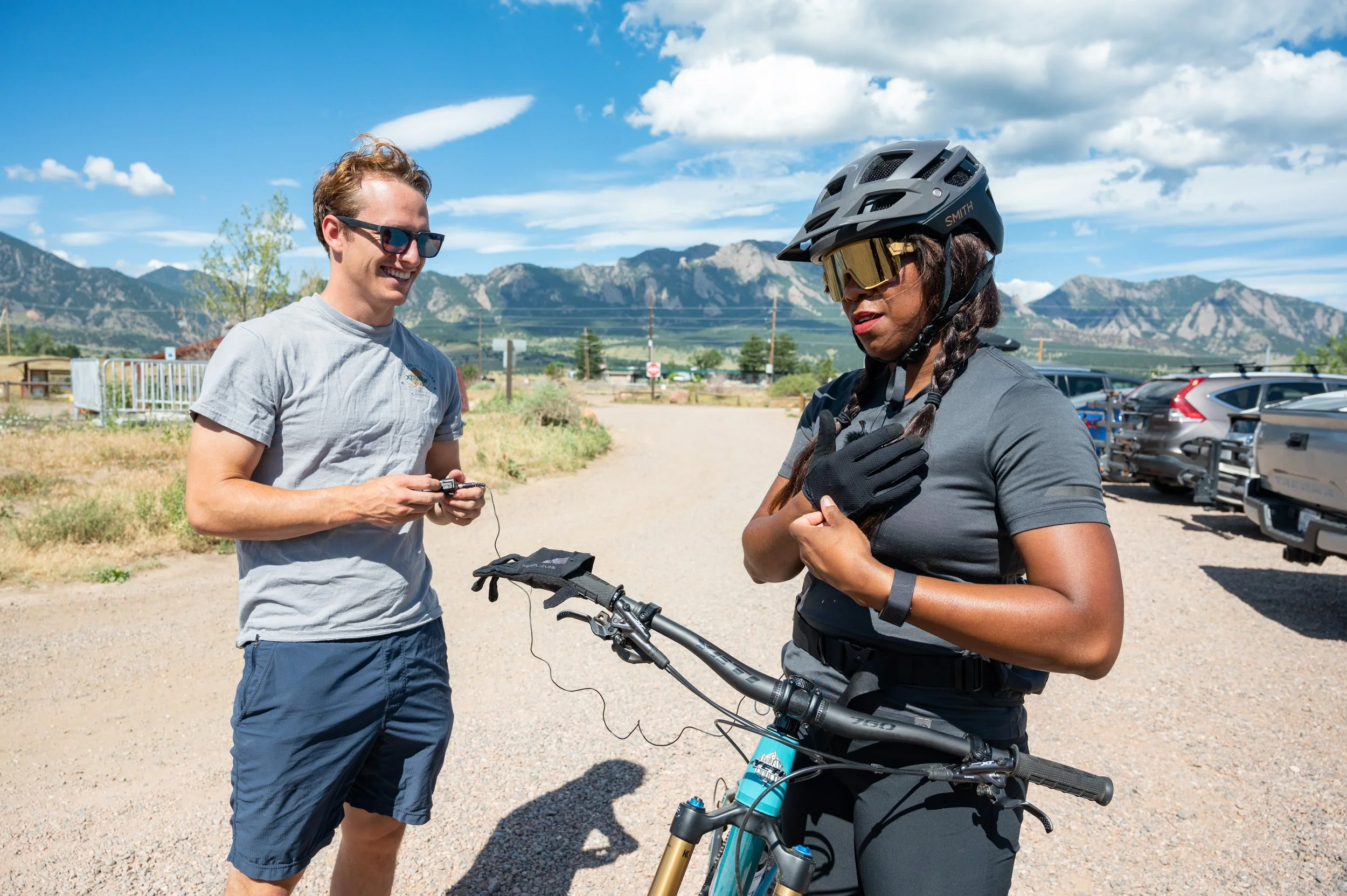 Roo Smith putting a microphone on a black female cyclist