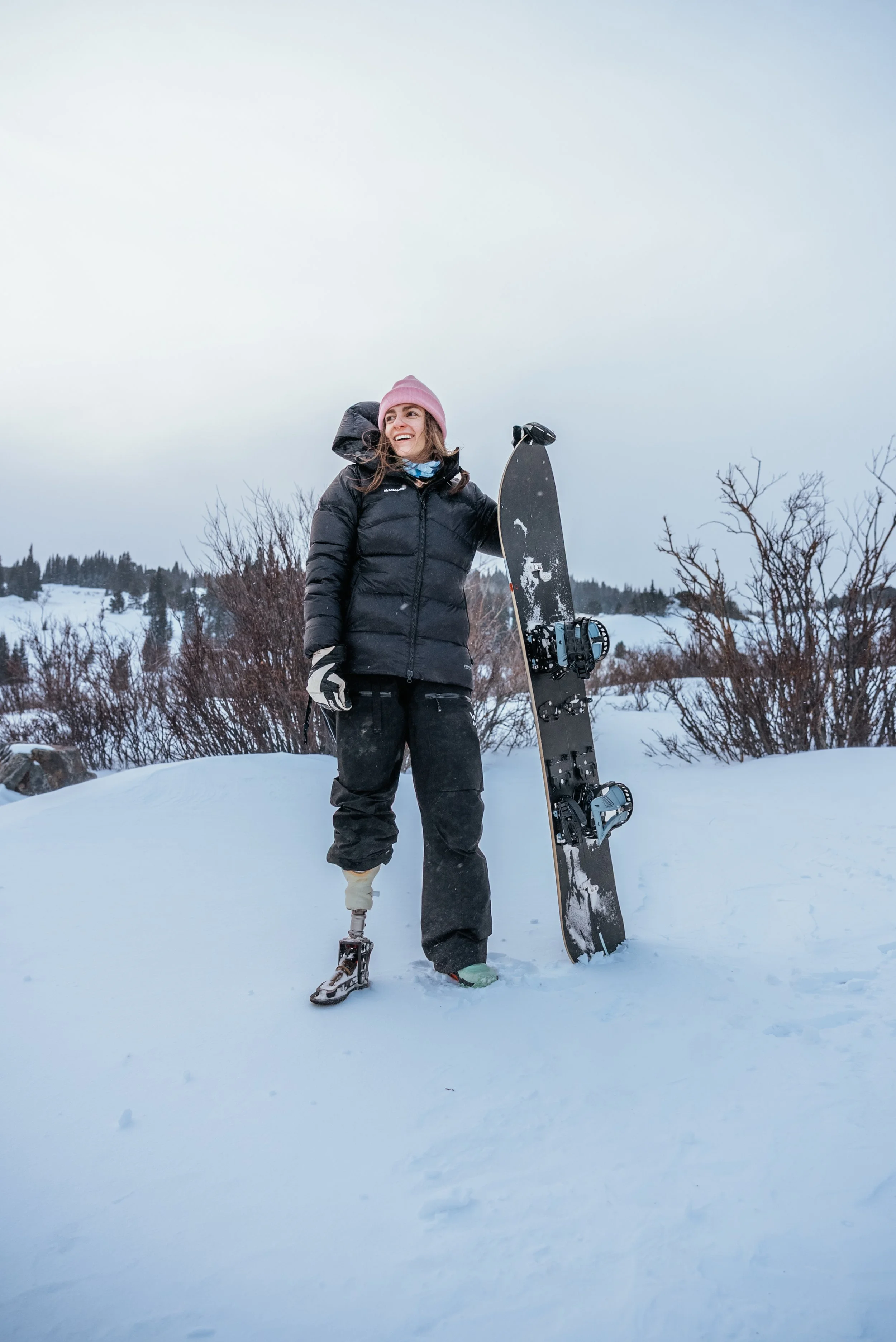 adaptive athlete Cail Soria posing with a snowboard