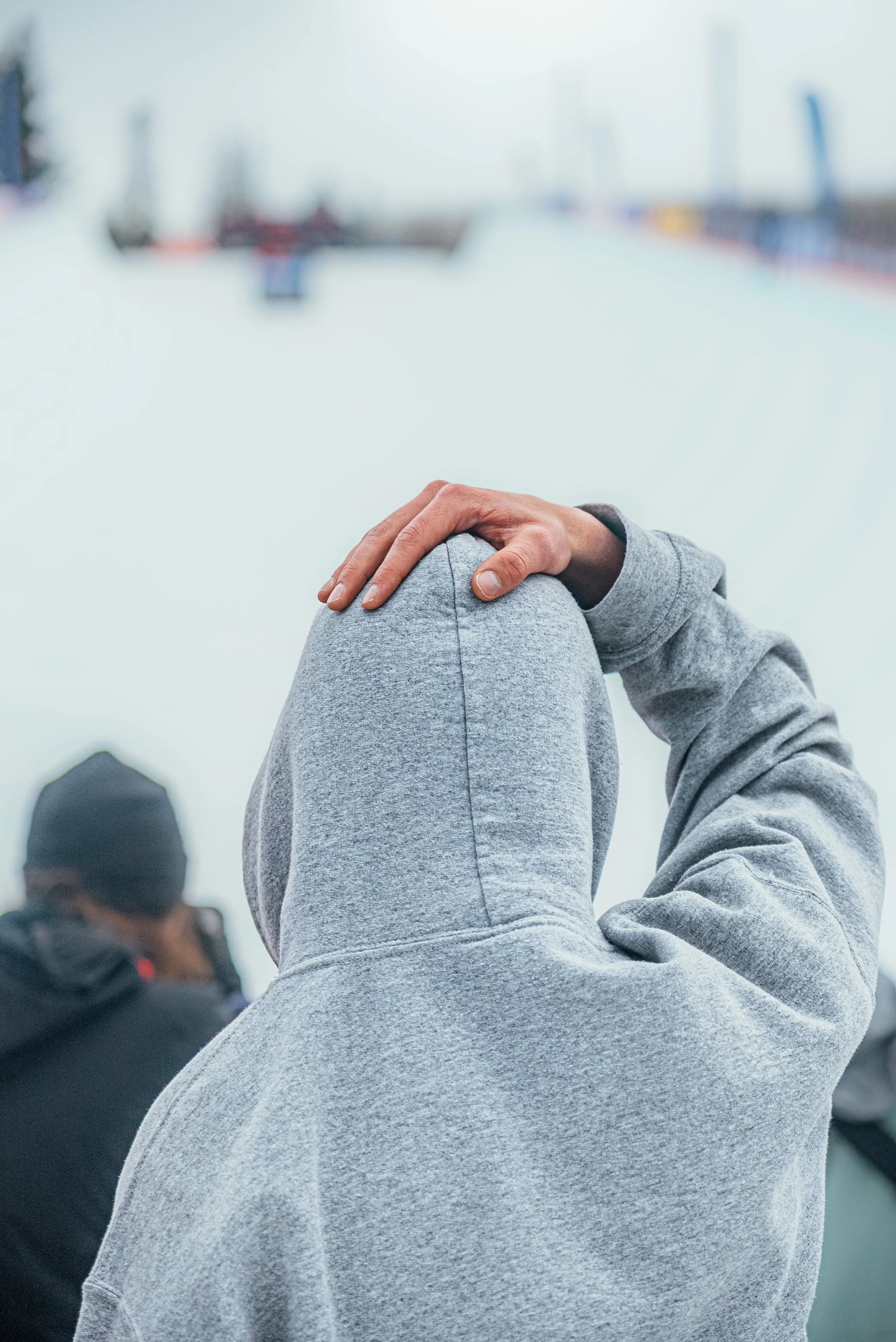 A snowboard fan at the bottom of the halfpipe with a hand on his head