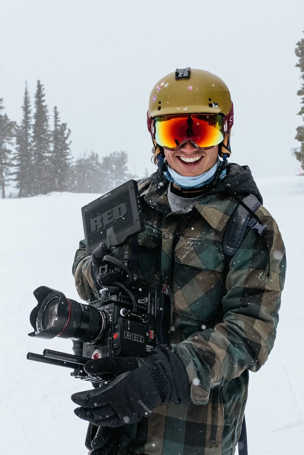 Adventure filmmaker Roo Smith holding a RED camera in the snow
