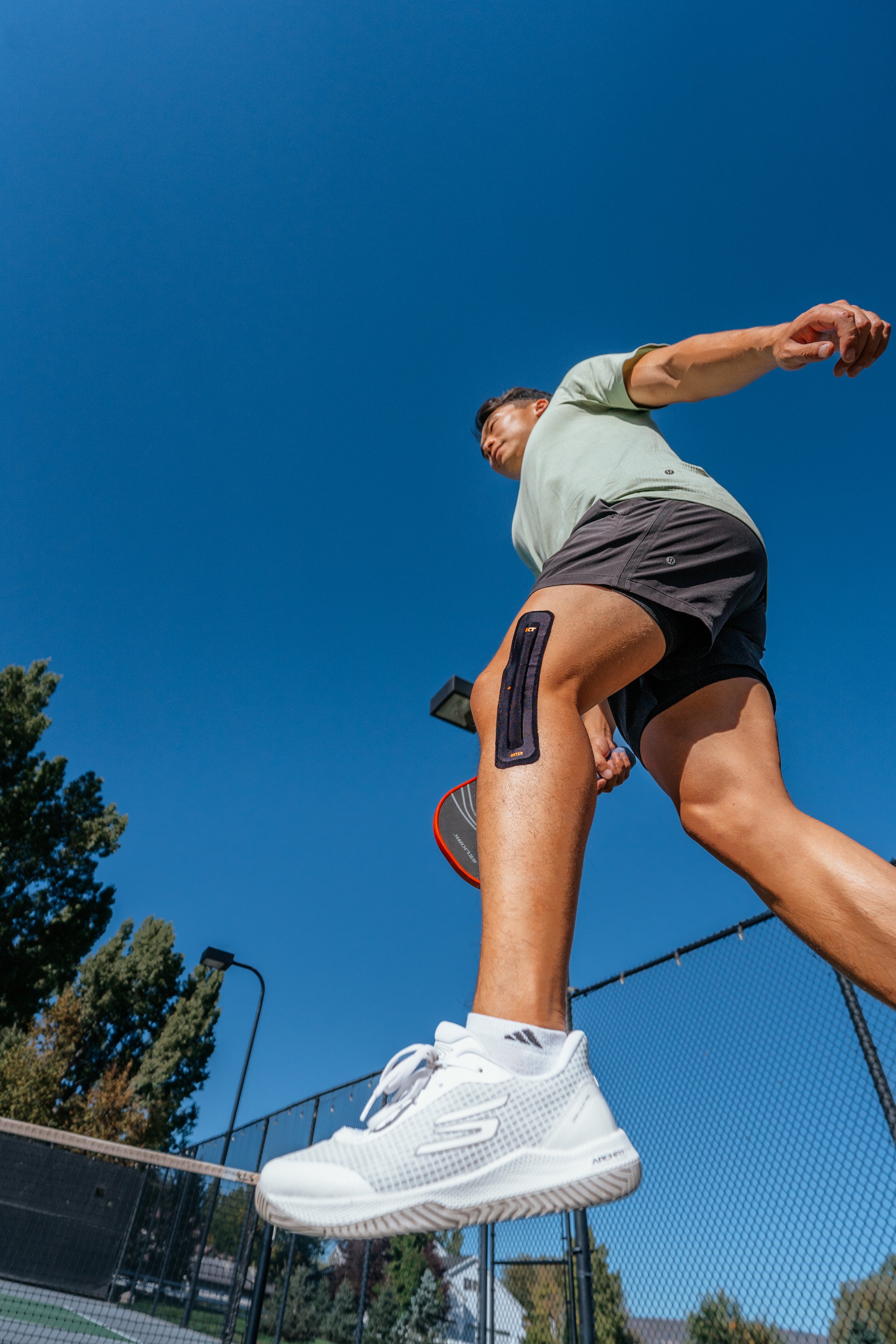 jumping photo of a man with KT Tape on his knee