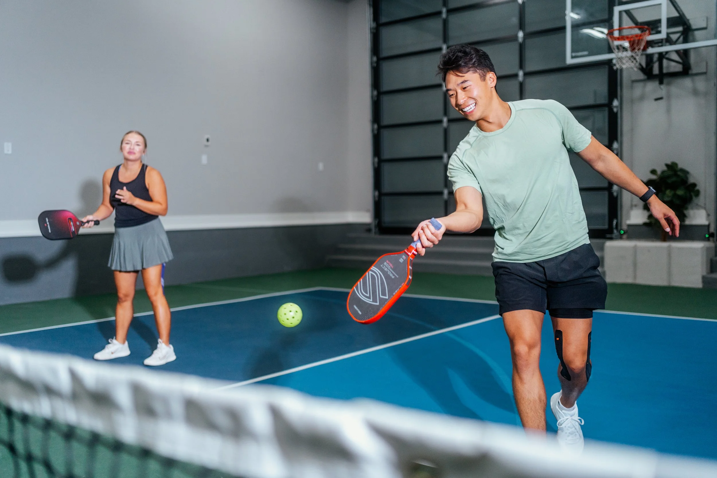 smiling man playing pickleball