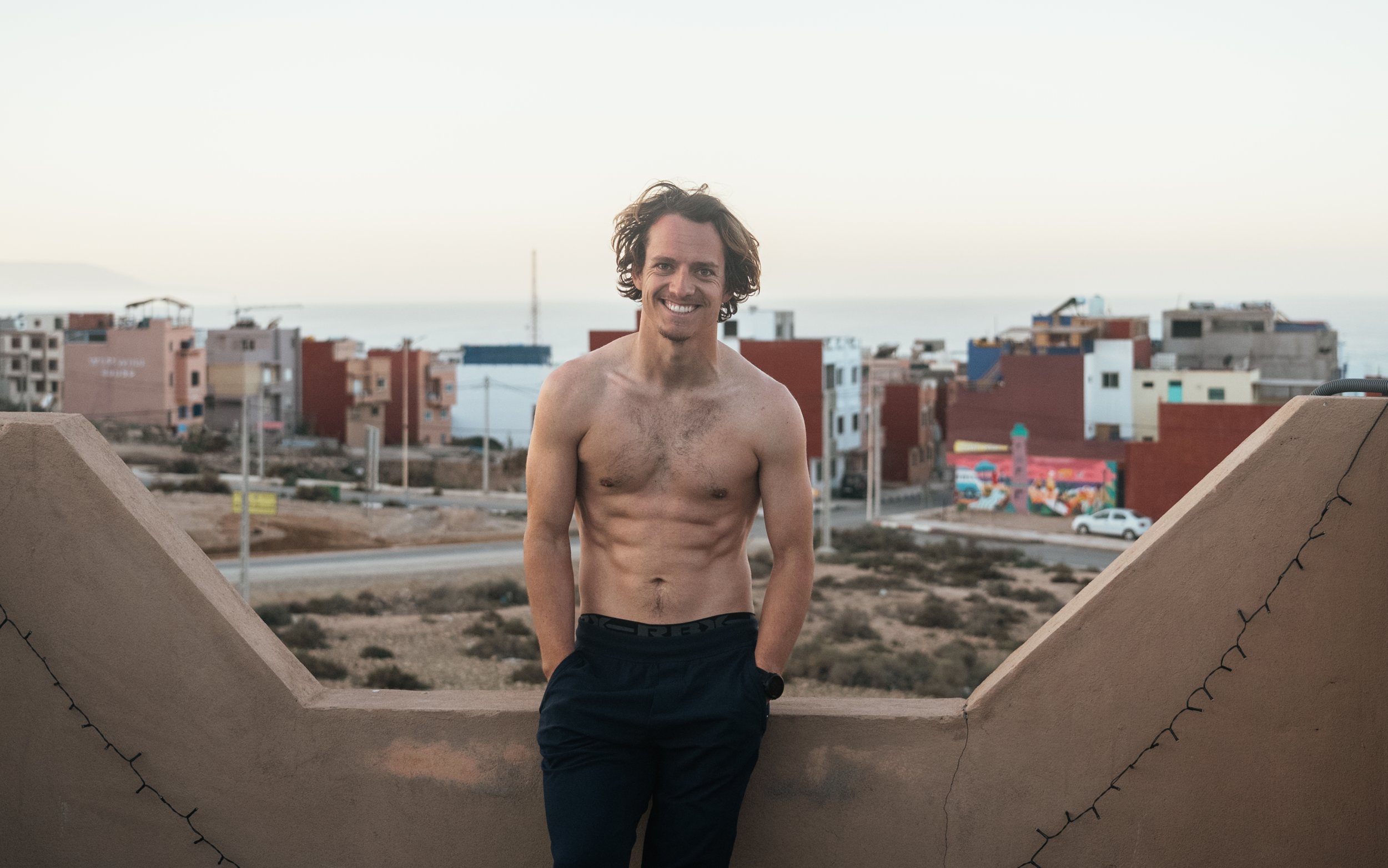 Roo shirtless on a rooftop in Morocco