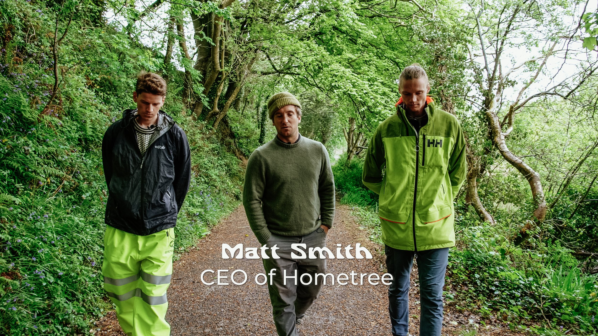 Three men walking through a lush green forest, wearing outdoor clothing. The overlay text reads 'Matt Smith, CEO of Hometree'.