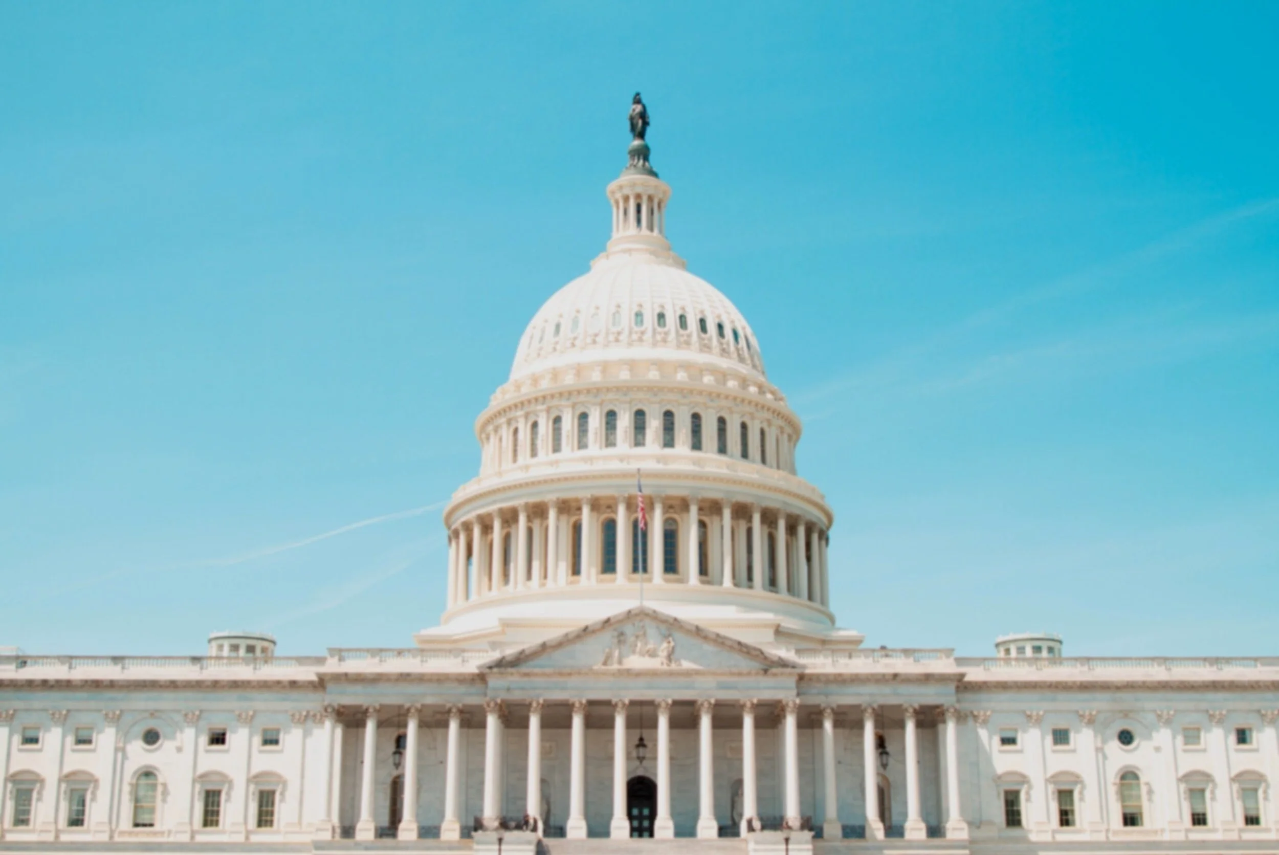 The United States Capitol building under a clear blue sky.