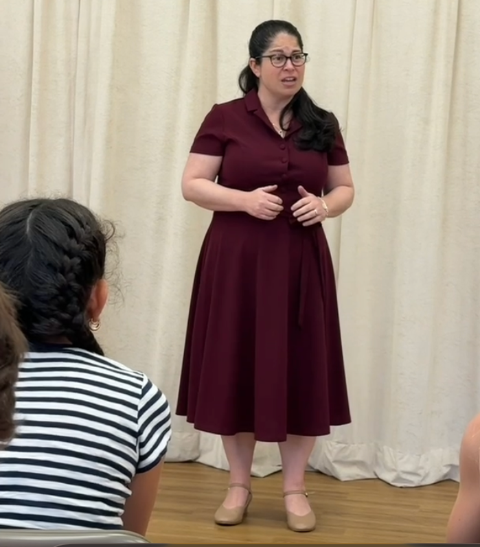 Woman in a red dress and glasses sings