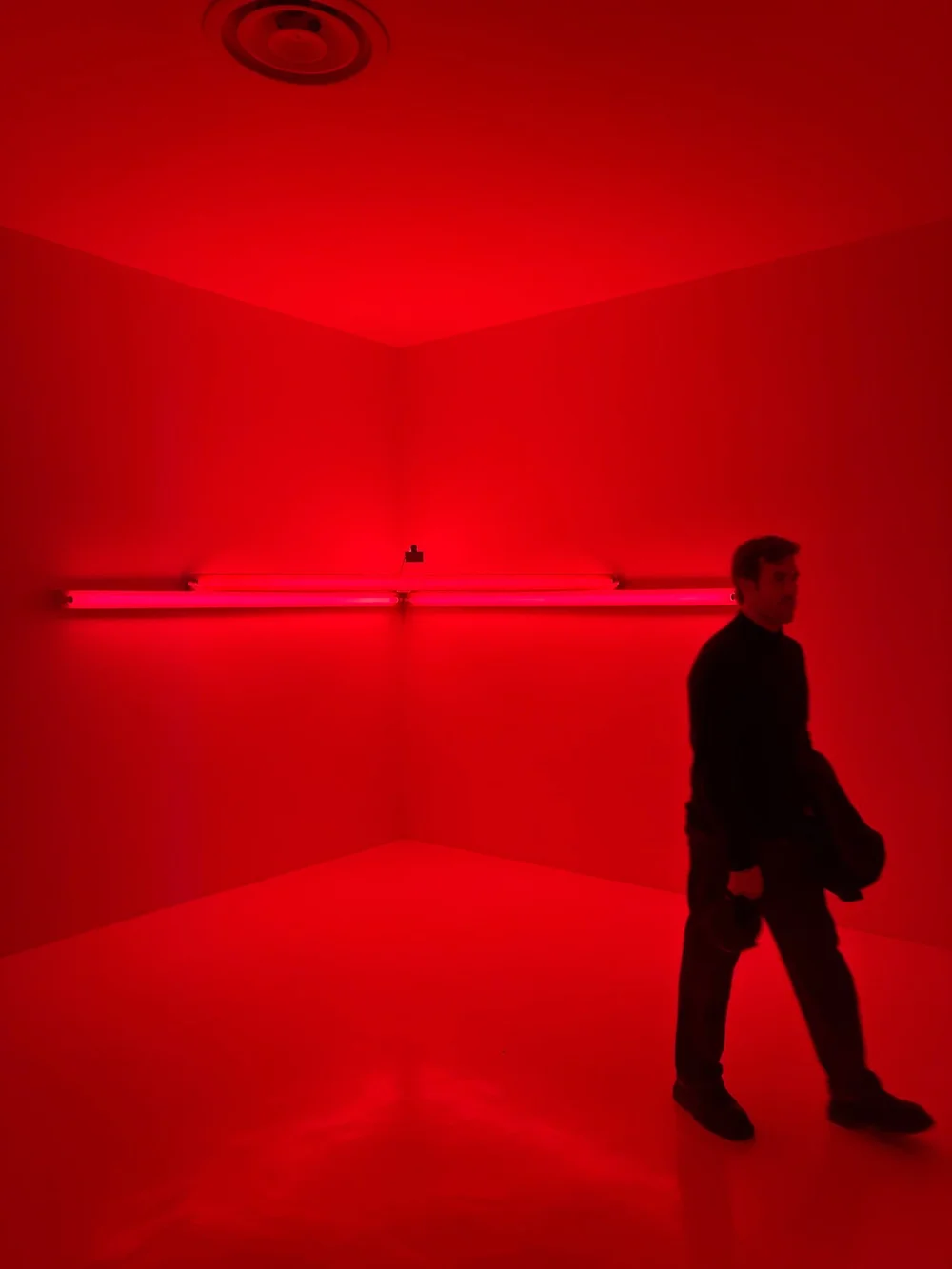 Un visitatore attraversa la stanza rossa di Dan Flavin, monument 4 for those who have been killed in ambush, a Villa Panza