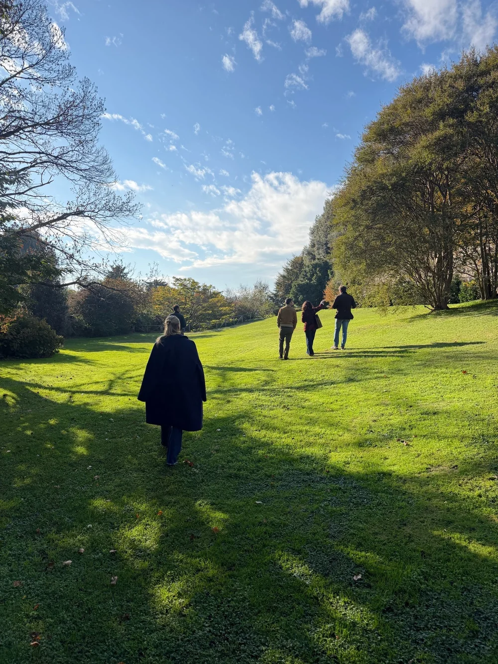Amici che passeggiano sul prato del parco di Villa Panza in una giornata di sole d'autunno