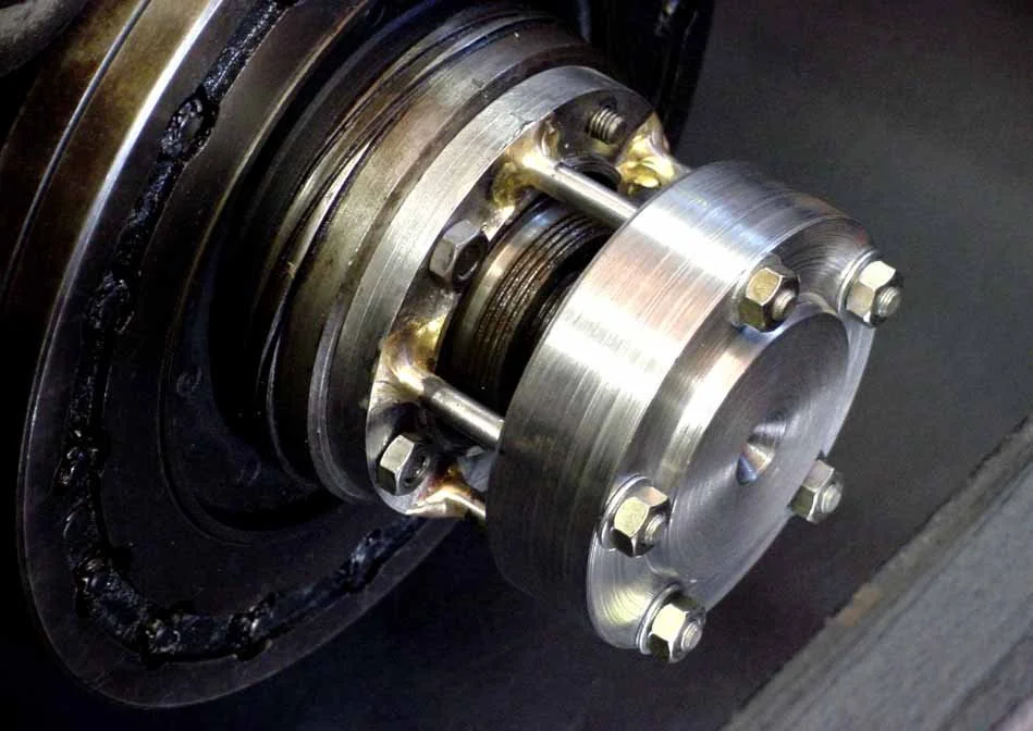 Photo 6:  The tool shown in position on the front of the crankshaft and ready to apply pull on the damper towards the front. One of the damper stud nuts is off to show the amount of threads that are used.