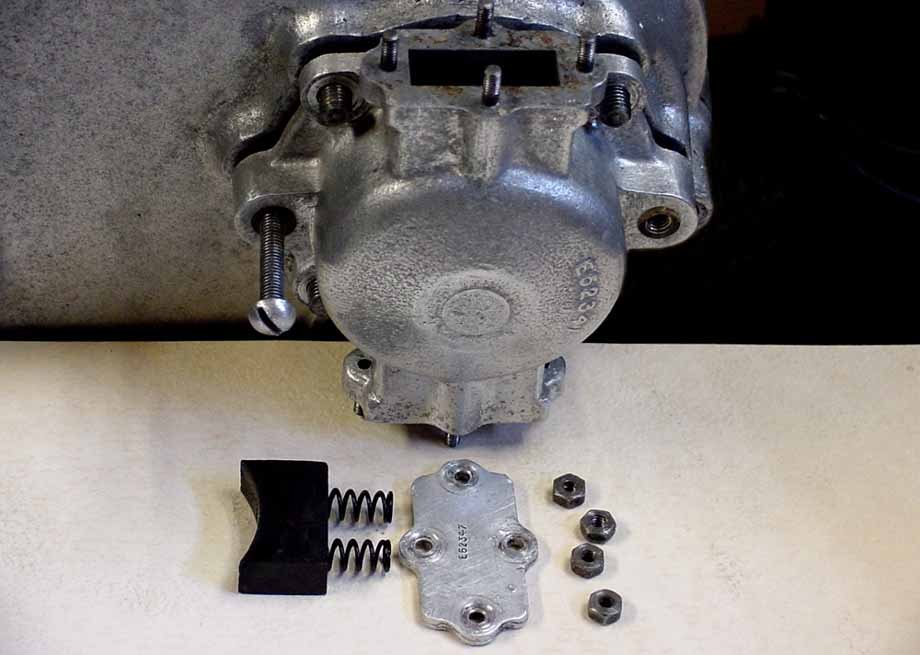 Photo 1: The dynamo drive brake mechanism must be removed  before the timing cover.  There are two sets of the parts shown that come out of the top and bottom of the drive cover. Shown is one of two 3/16” B.S.F. bolts that may be used to force the co