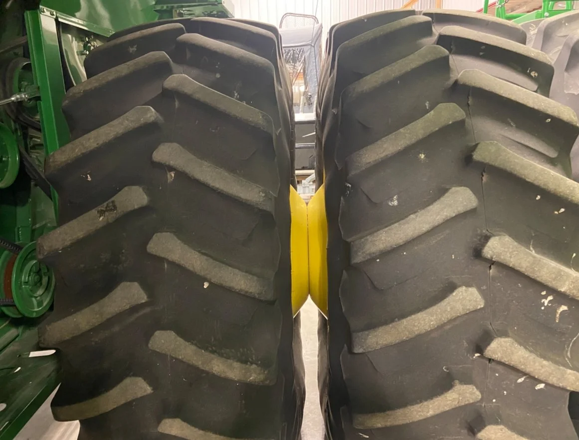 Close-up of two large tractor tires with deep treads, used for off-road farming or construction machinery.