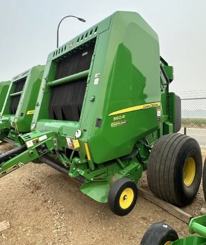 Green John Deere 560R round baler parked on a dirt surface