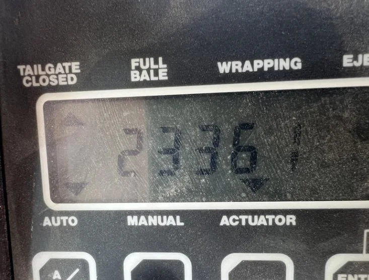 Close-up of a digital control panel with a display showing 23,361 and labels for different modes like Tailgate Closed, Full Bale, Wrapping, and Eject.