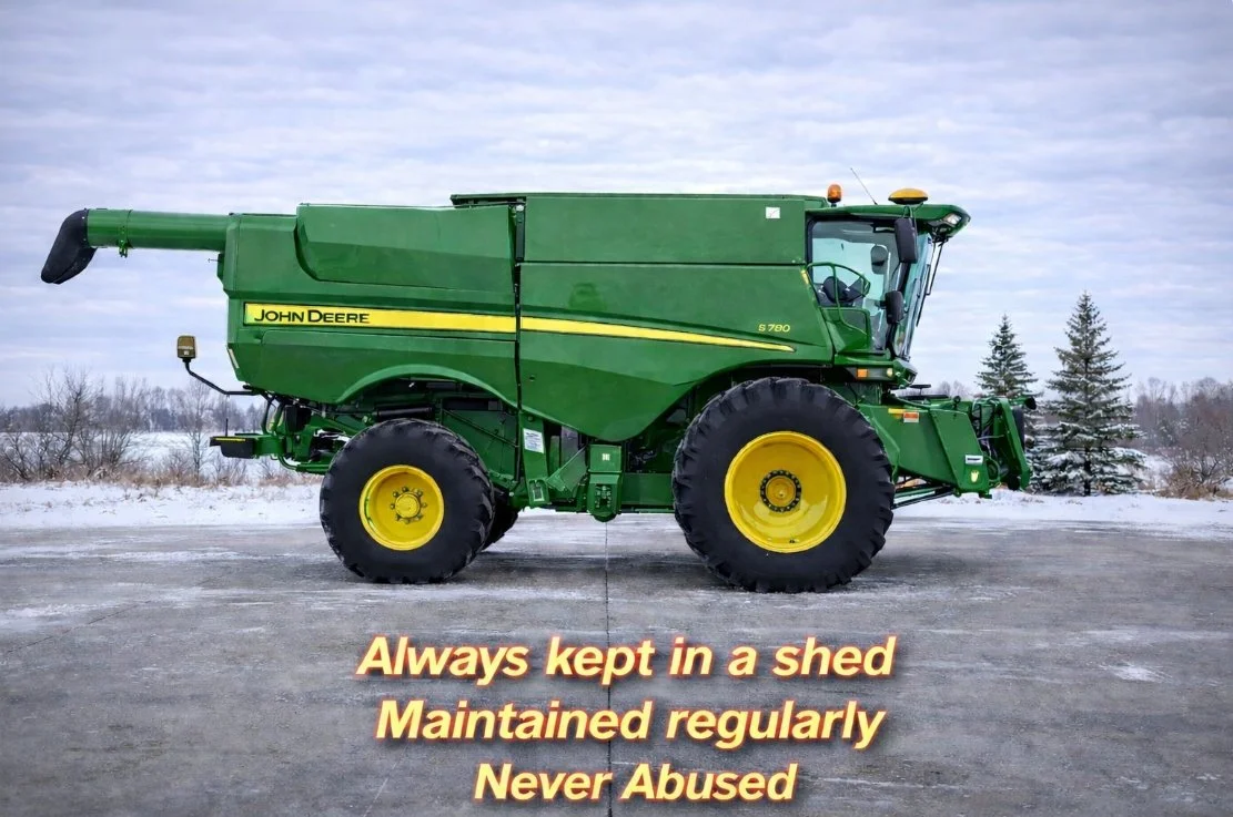 A green John Deere S780 combine harvester parked on a snow-covered surface with a cloudy sky in the background.