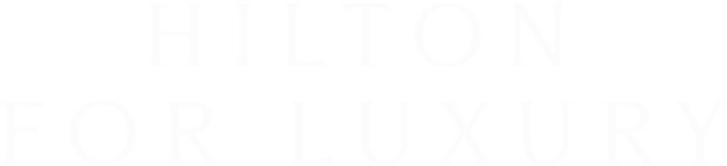 The image displays the Hilton logo with the tagline "for luxury" written underneath in white text on a black background.