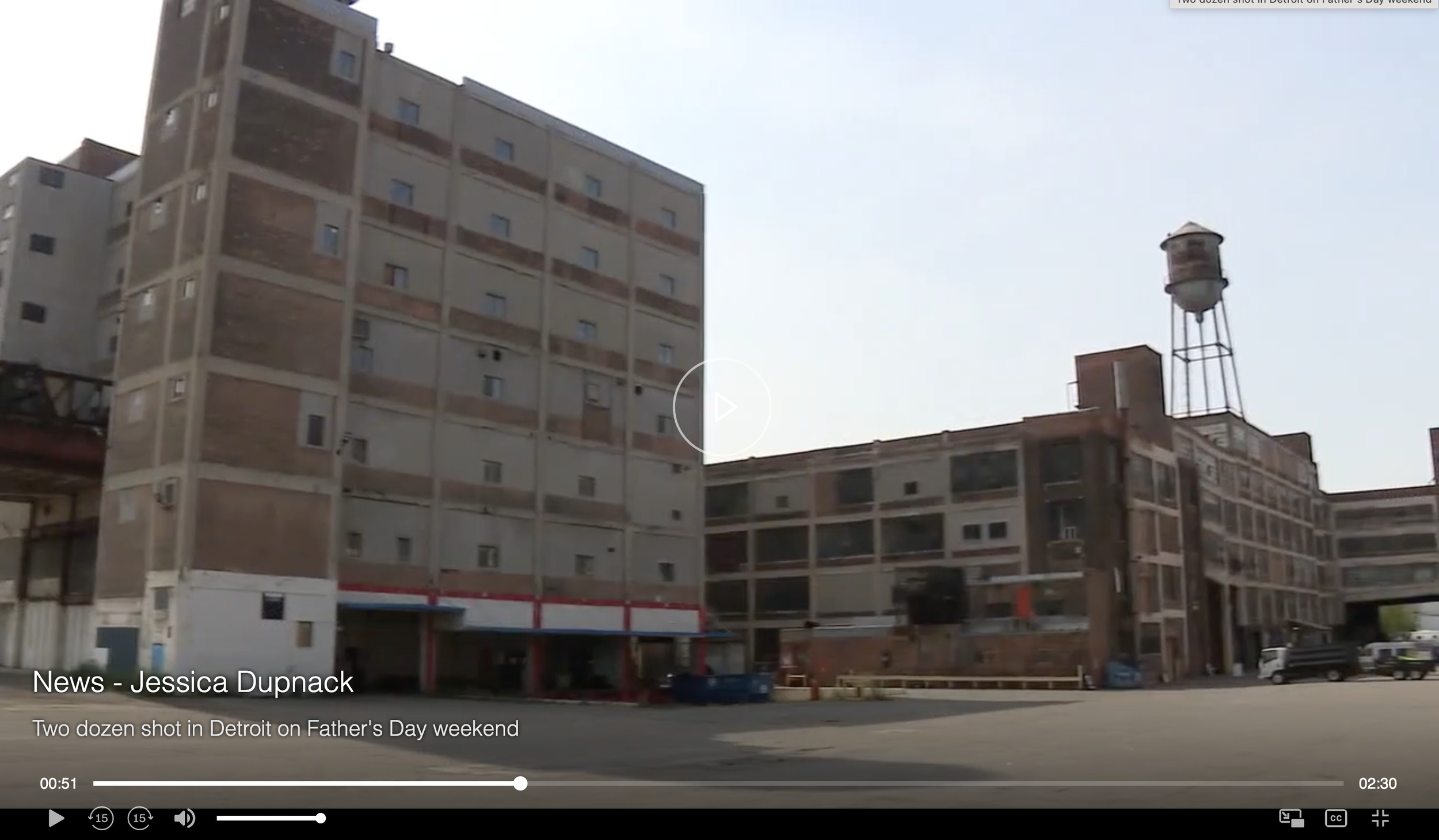 An old multi-story brick and concrete building with a water tower on the roof in Detroit, Michigan.