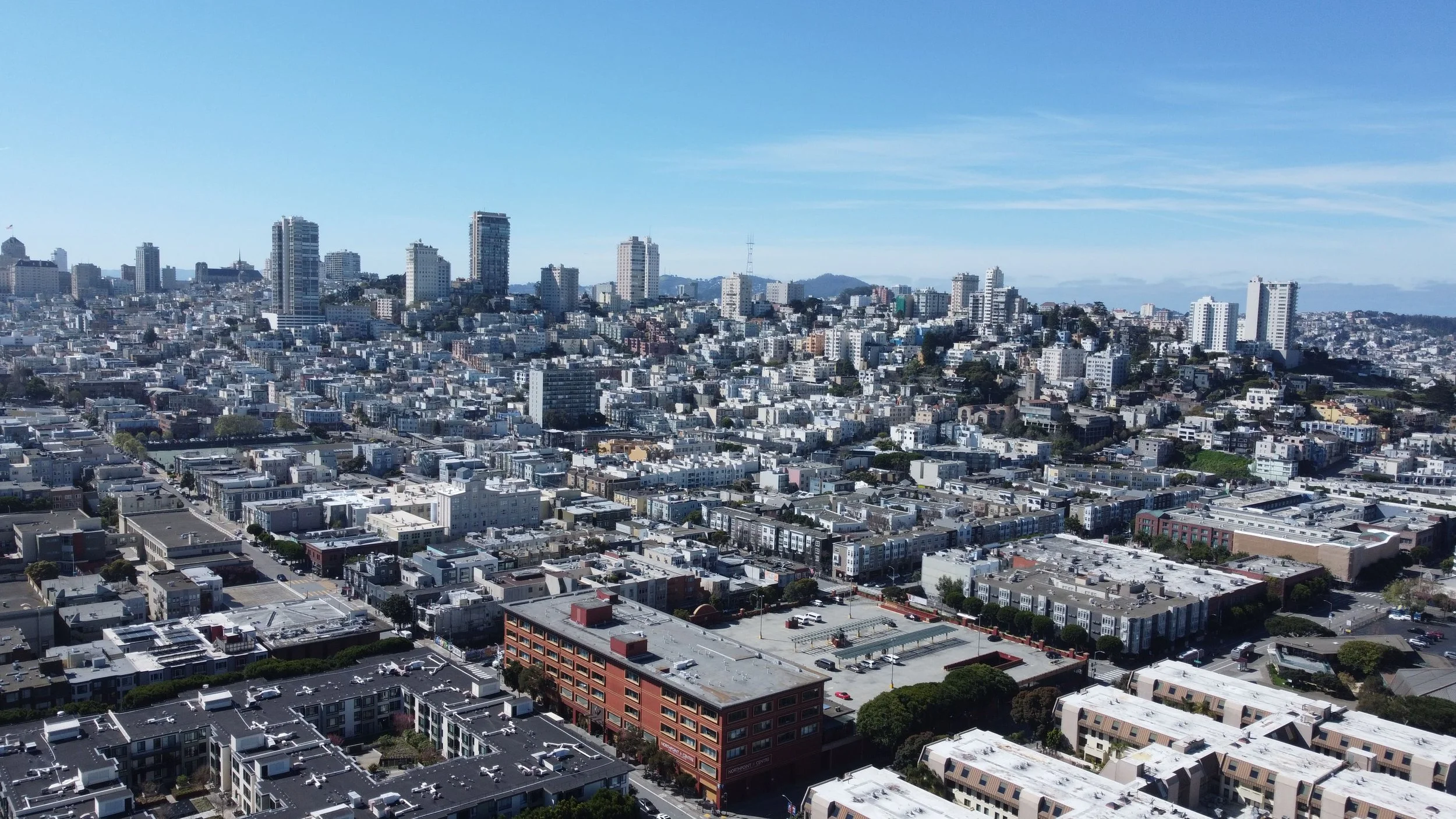A cityscape of San Francisco with high-rise buildings, neighborhoods, and blue sky.