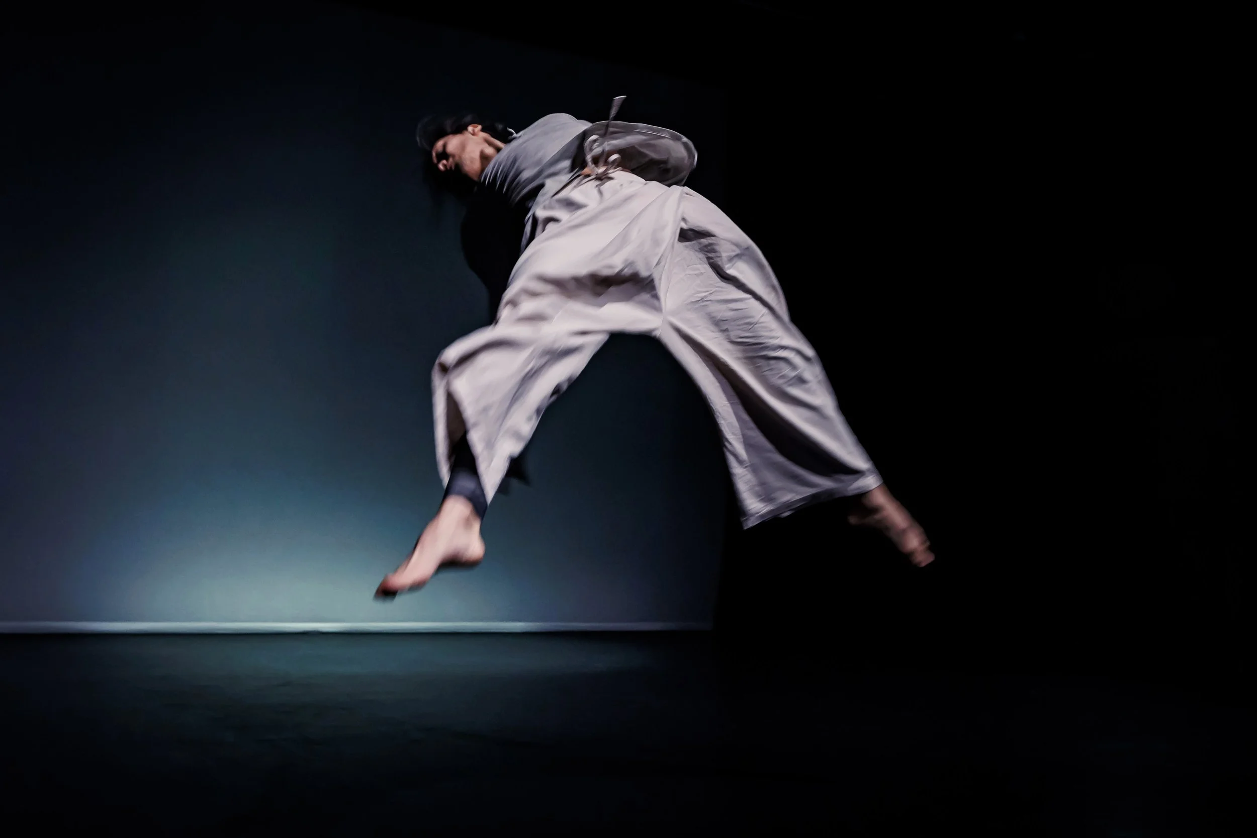 Dancer Kenny Ho performing a barrel jump on stage. From the dance solo ma.