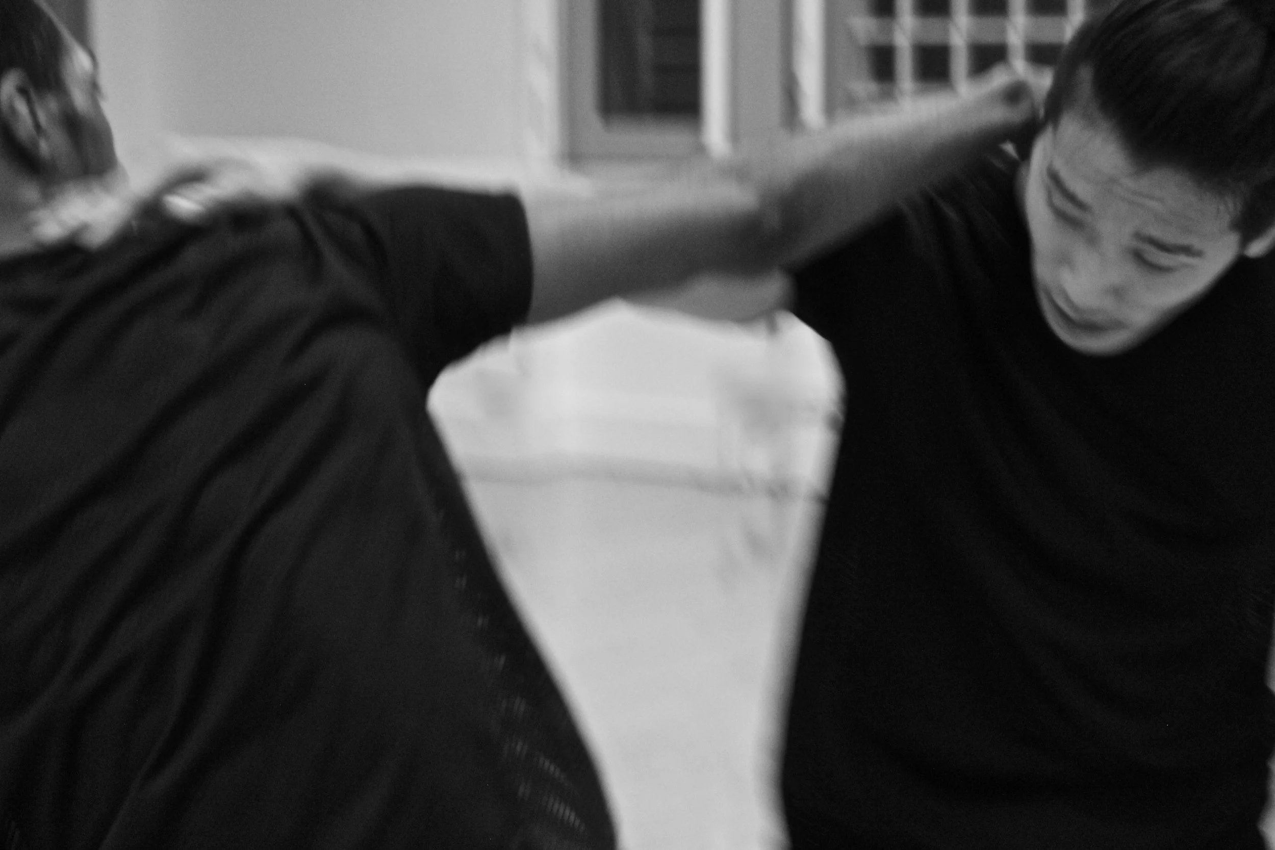 Kenny Ho and Ihsaan De Banya engaged in a physical dance with an arm stretch behind each others neck. From the choreography Casting Shadows.