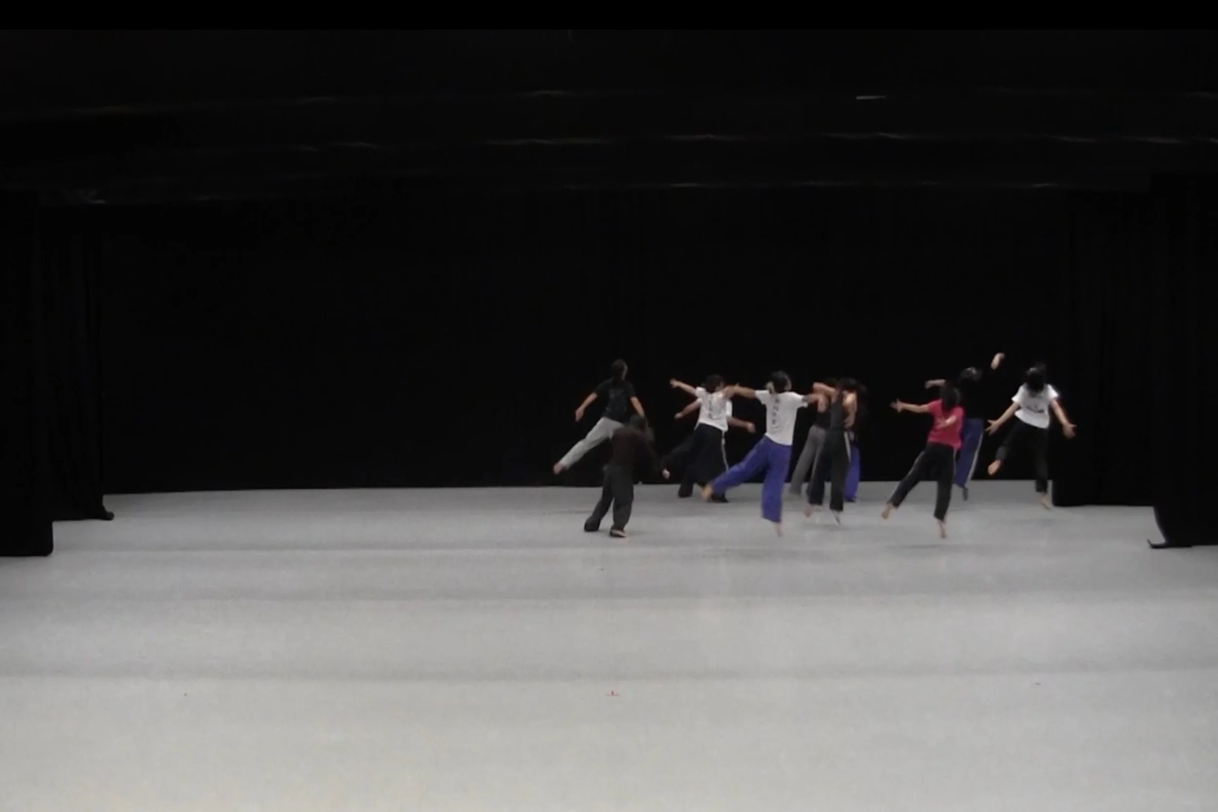 Dancers on stage with multiple dancers leaping into the air. From the choreography WALLS.
