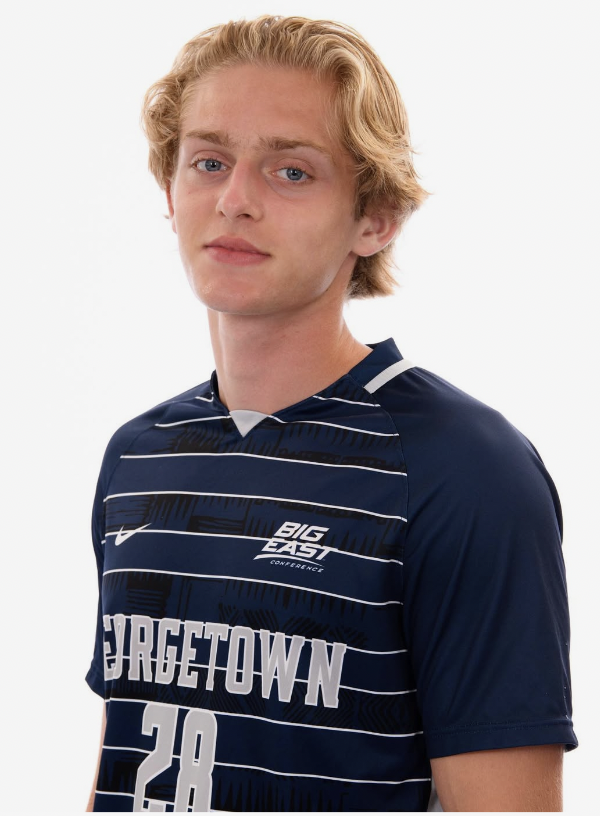 A young man with blonde hair wearing a navy blue sports jersey with white horizontal stripes, the words 'BIGEAST CONFERENCE' and 'BURGETOWN 28' printed on it.