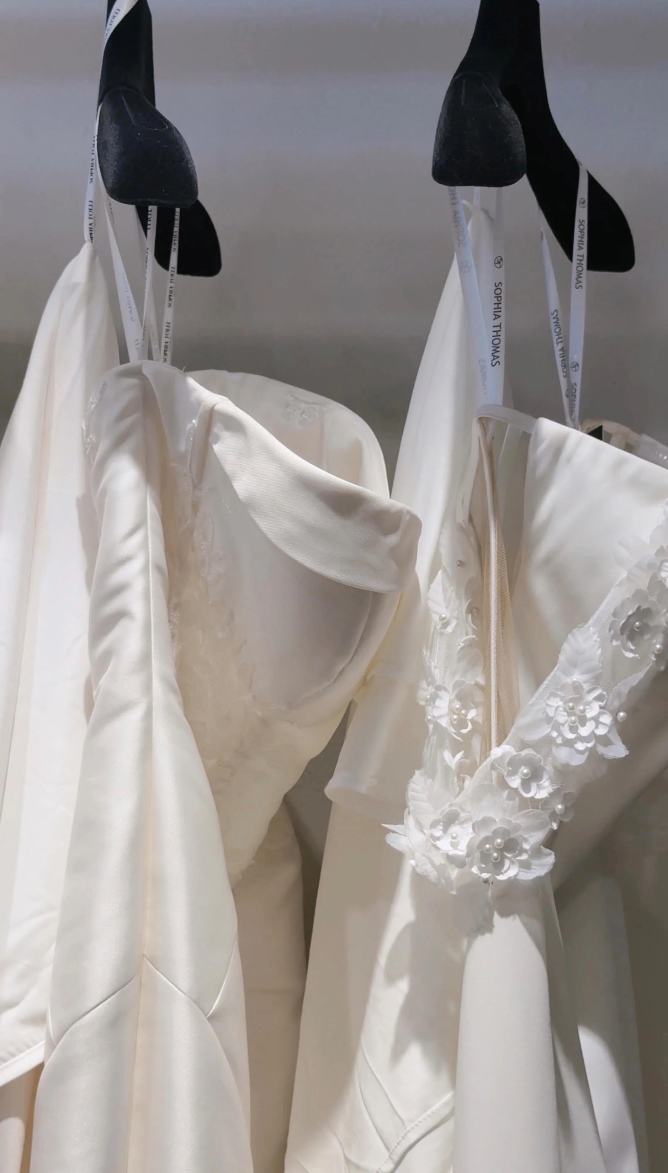 two wedding dresses on hangers