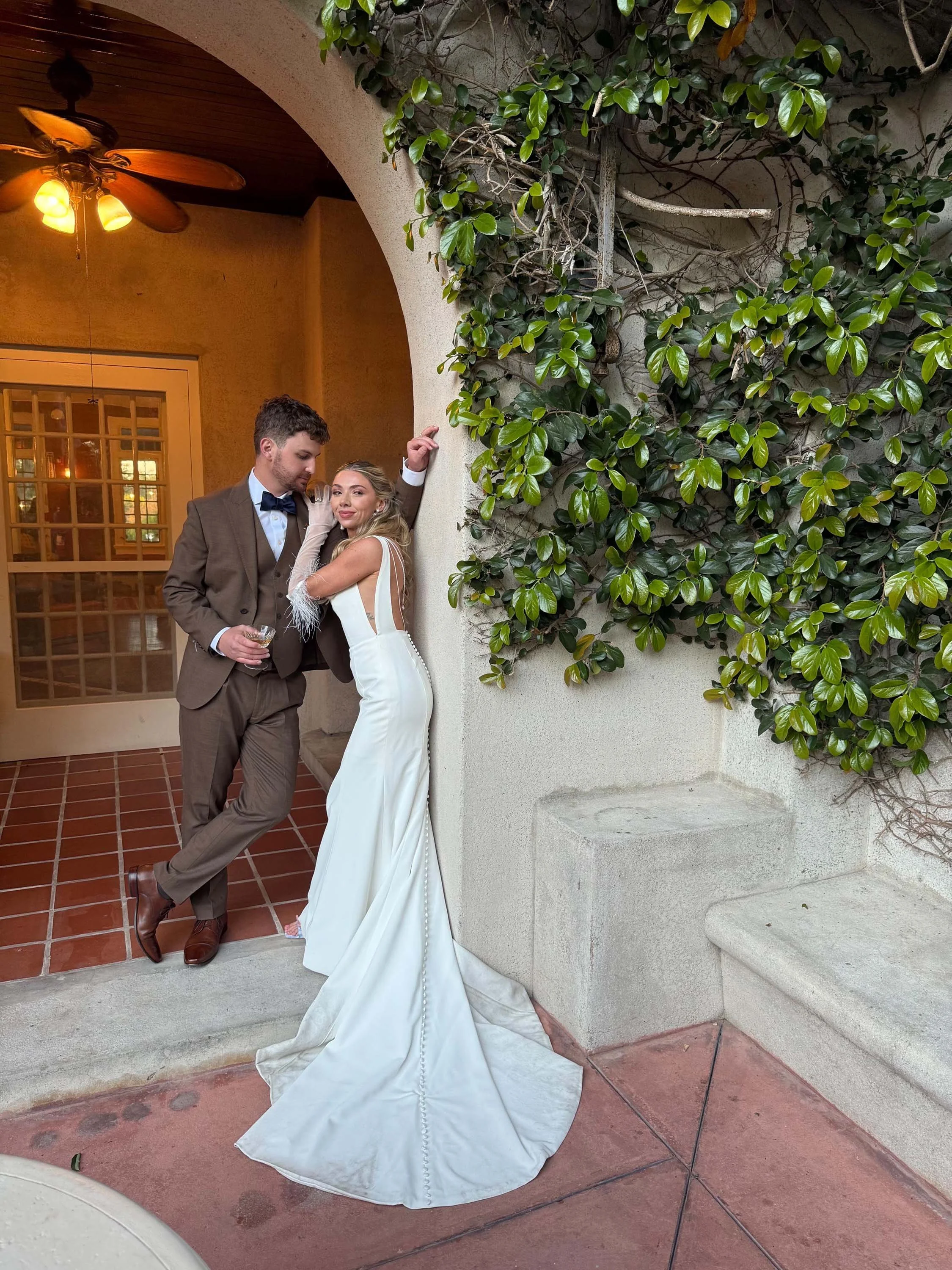bride and groom posing in an archway