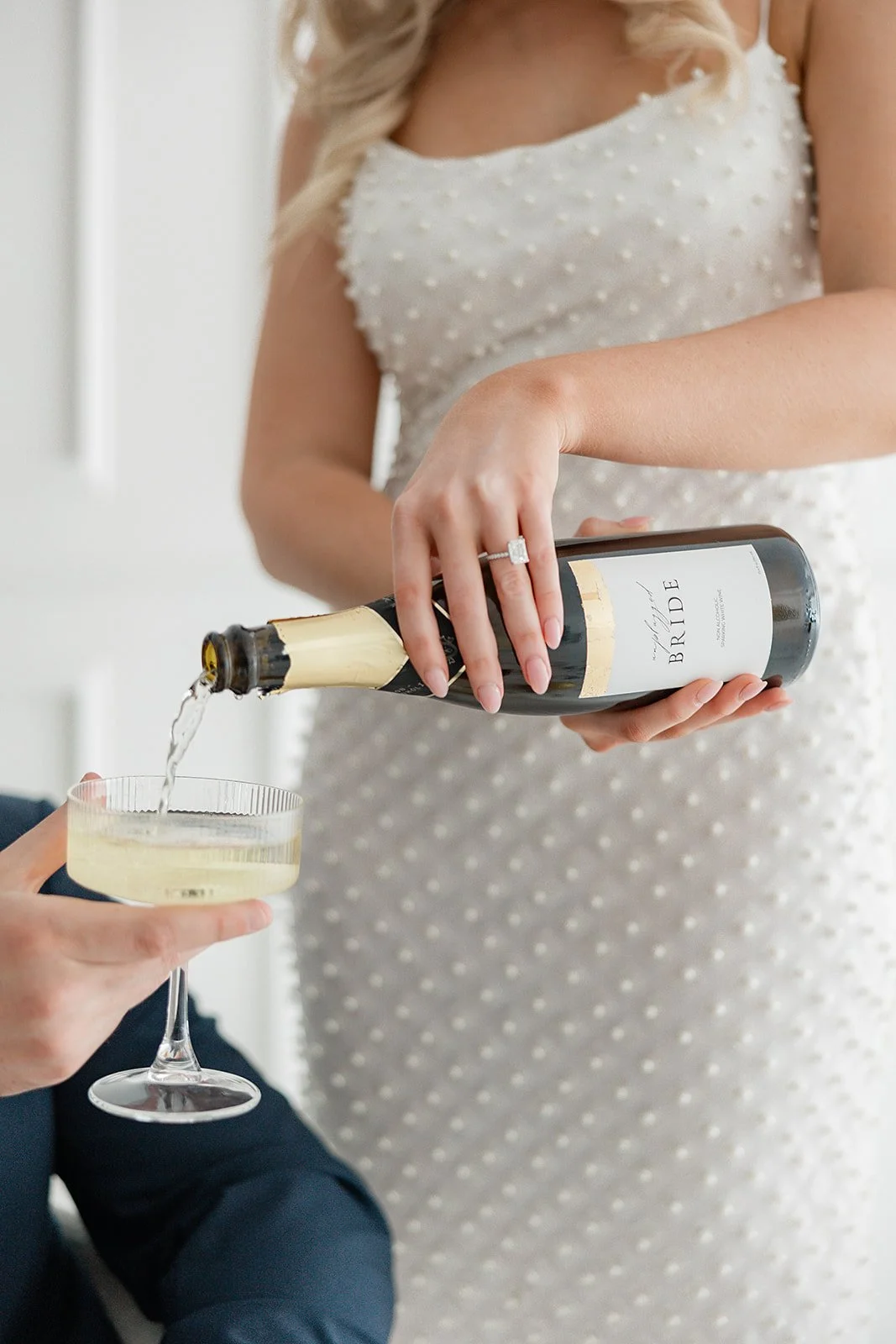 bride pouring champagne into a glass