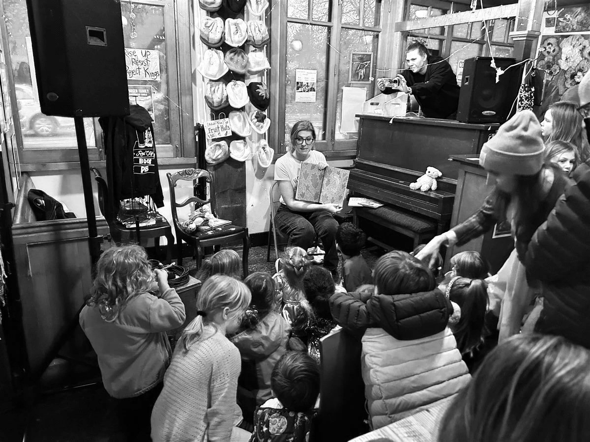 A woman reading a book to a group of children at the Book Pub in Portland.