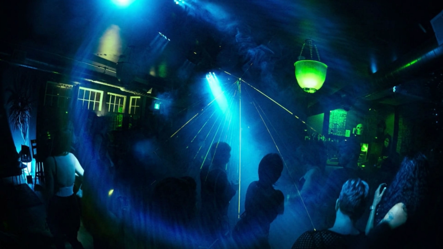 A dark, moody shot of the venue with fog and lasers.