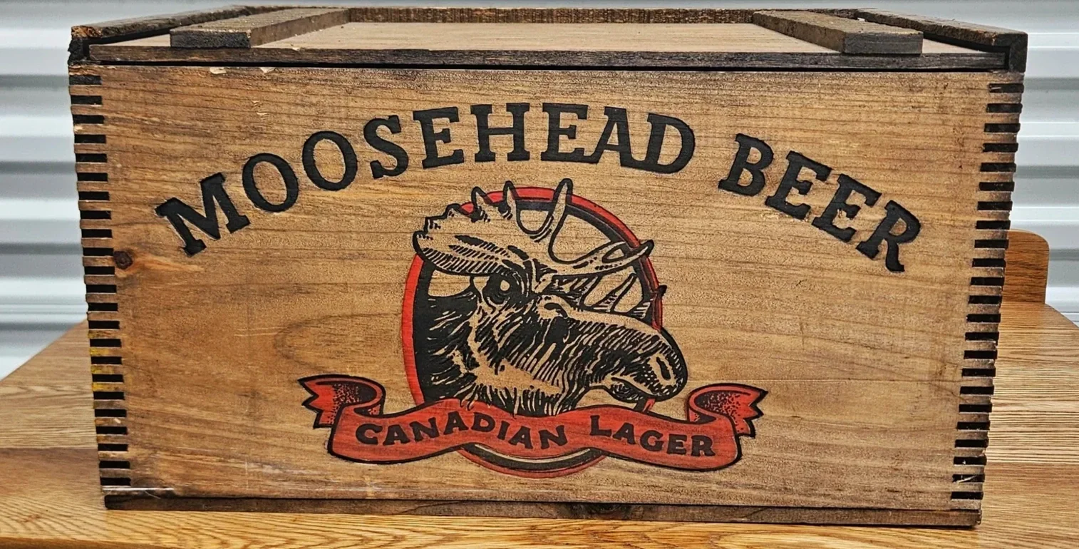 Wooden beer caddy featuring the Moosehead Beer logo with a moose head illustration and the text 'Moosehead Beer Canadian Lager'.