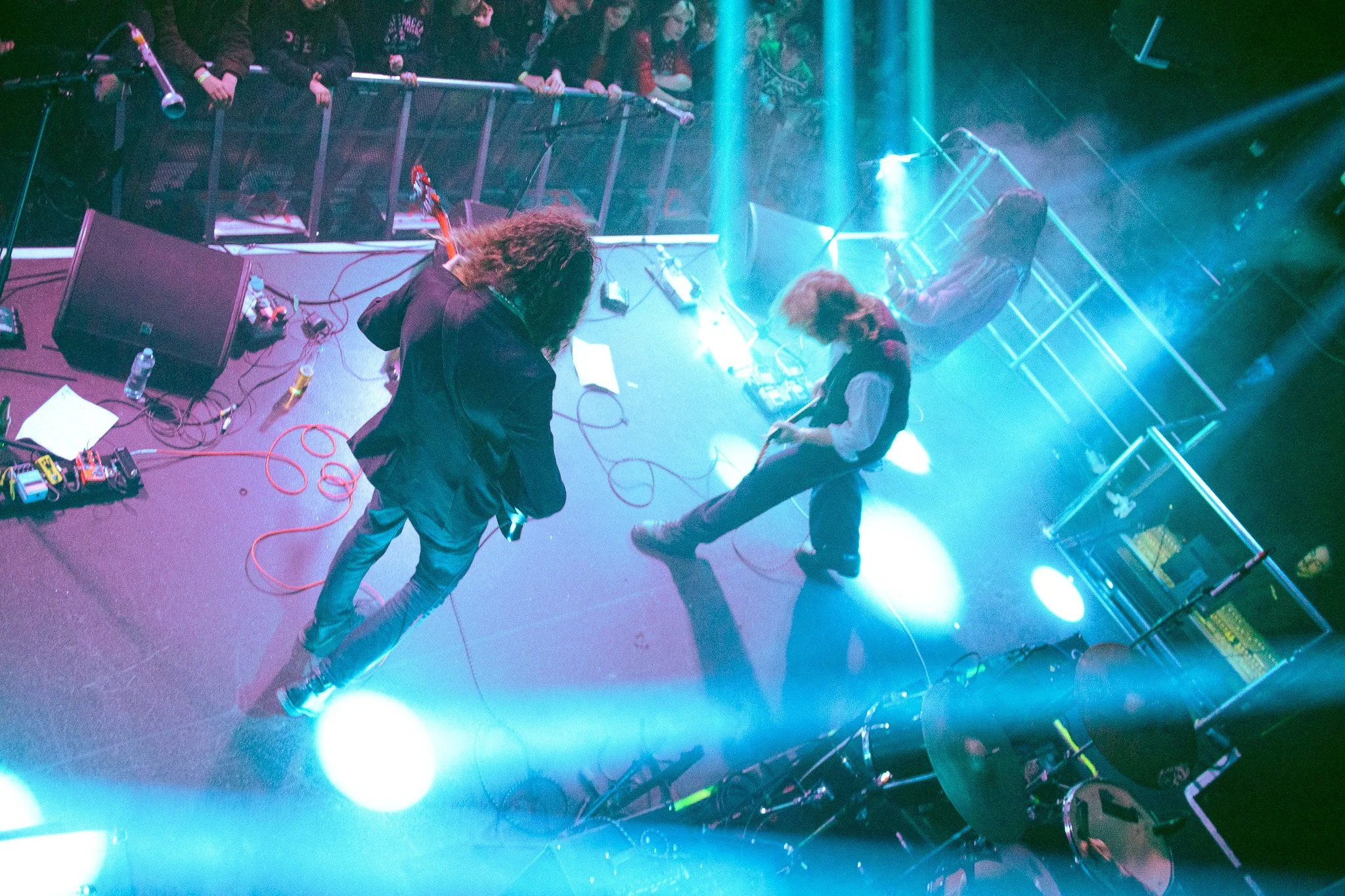 The Love Buzz, Irish Band performing in The Acadmey at IADT Ball. Two musicians performing on stage with blue lighting, one playing an instrument and the other striking a pose, with an audience visible in the background. Irish Music photography. 