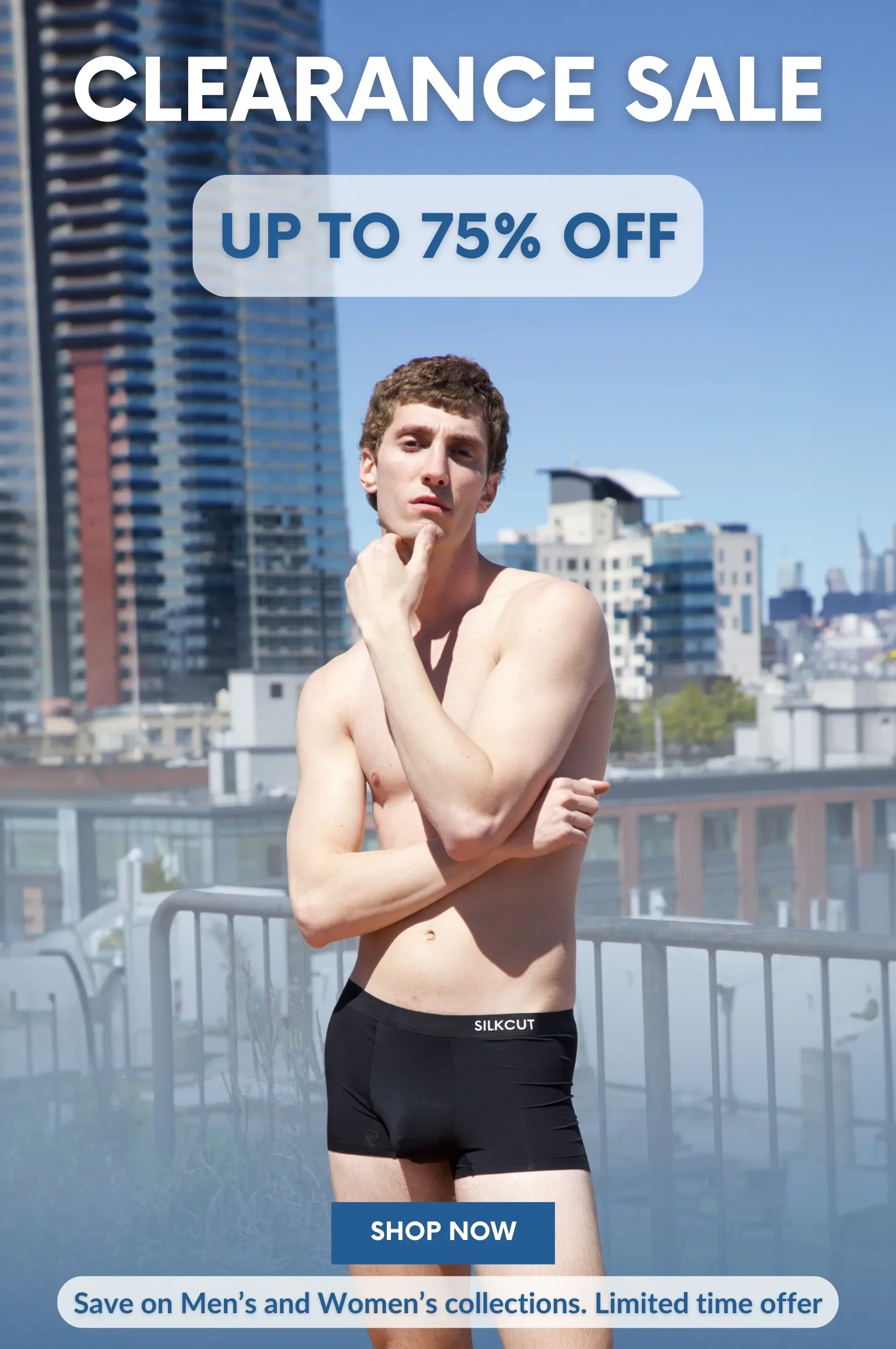 A shirtless young man with curly hair stands outdoors in front of a city skyline, with buildings and a clear blue sky behind him, promoting a clearance sale with discounts up to 75% off and a 'Shop Now' button.