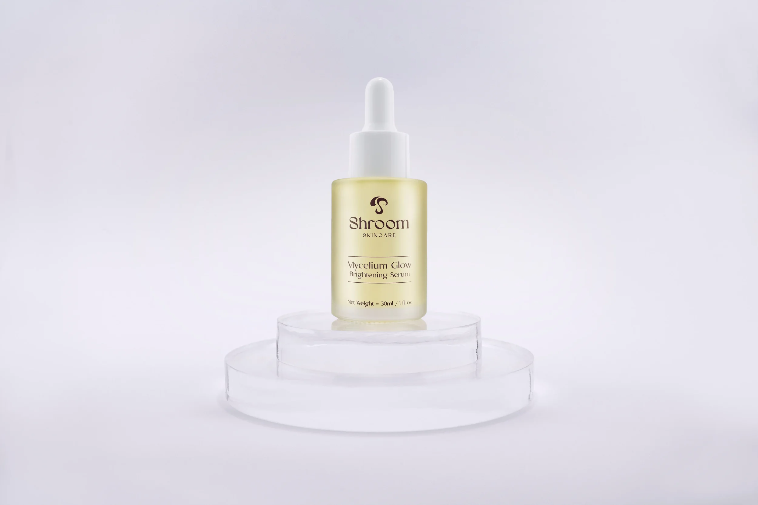 Shroom Skincare Mycelium Glow Brightening Serum displayed on a glass pedestal
