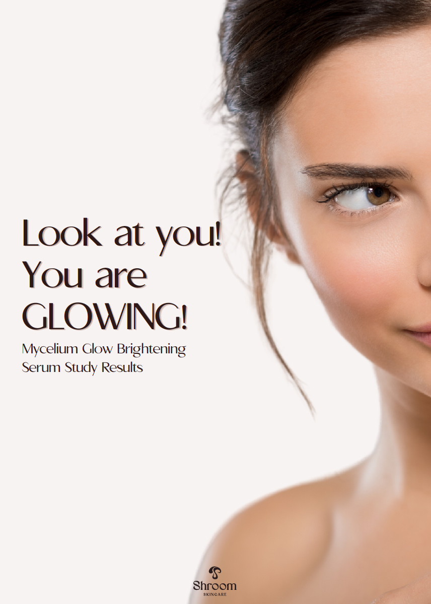 Close-up of a woman with smooth skin, smiling slightly, with part of her face and shoulder visible. The background is light-colored. Text on the image says, "Look at you! You are GLOWING!" and promotes Mycelium Glow Brightening Serum Study Results by Shroom Skincare.