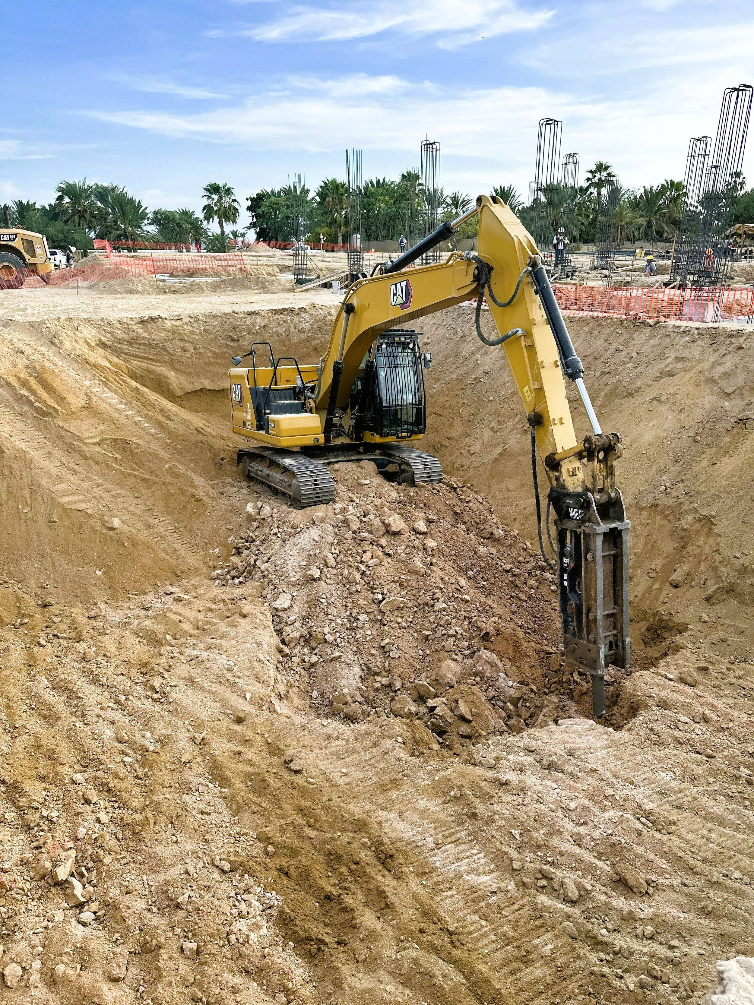 Excavadora caterpillar dentro de excavación profunda para cisterna, cortando material tipo c